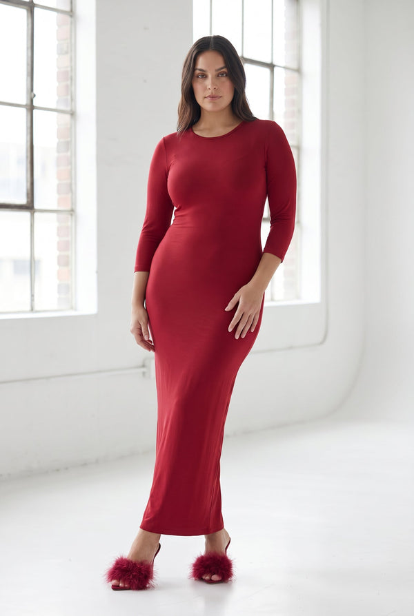 A woman wearing a long red maxi length layering dress.
