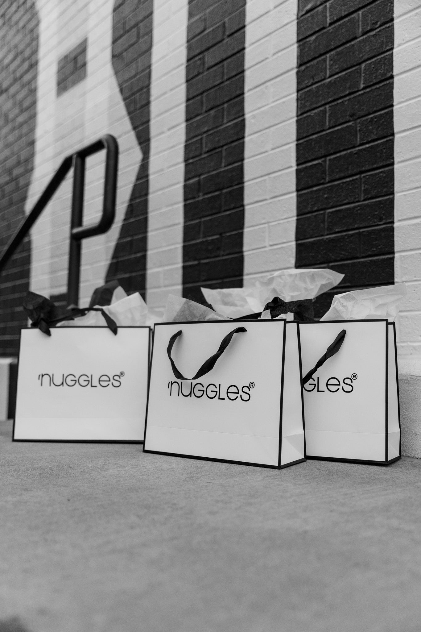 Nuggles® Shopping bags by a black and white wall. 