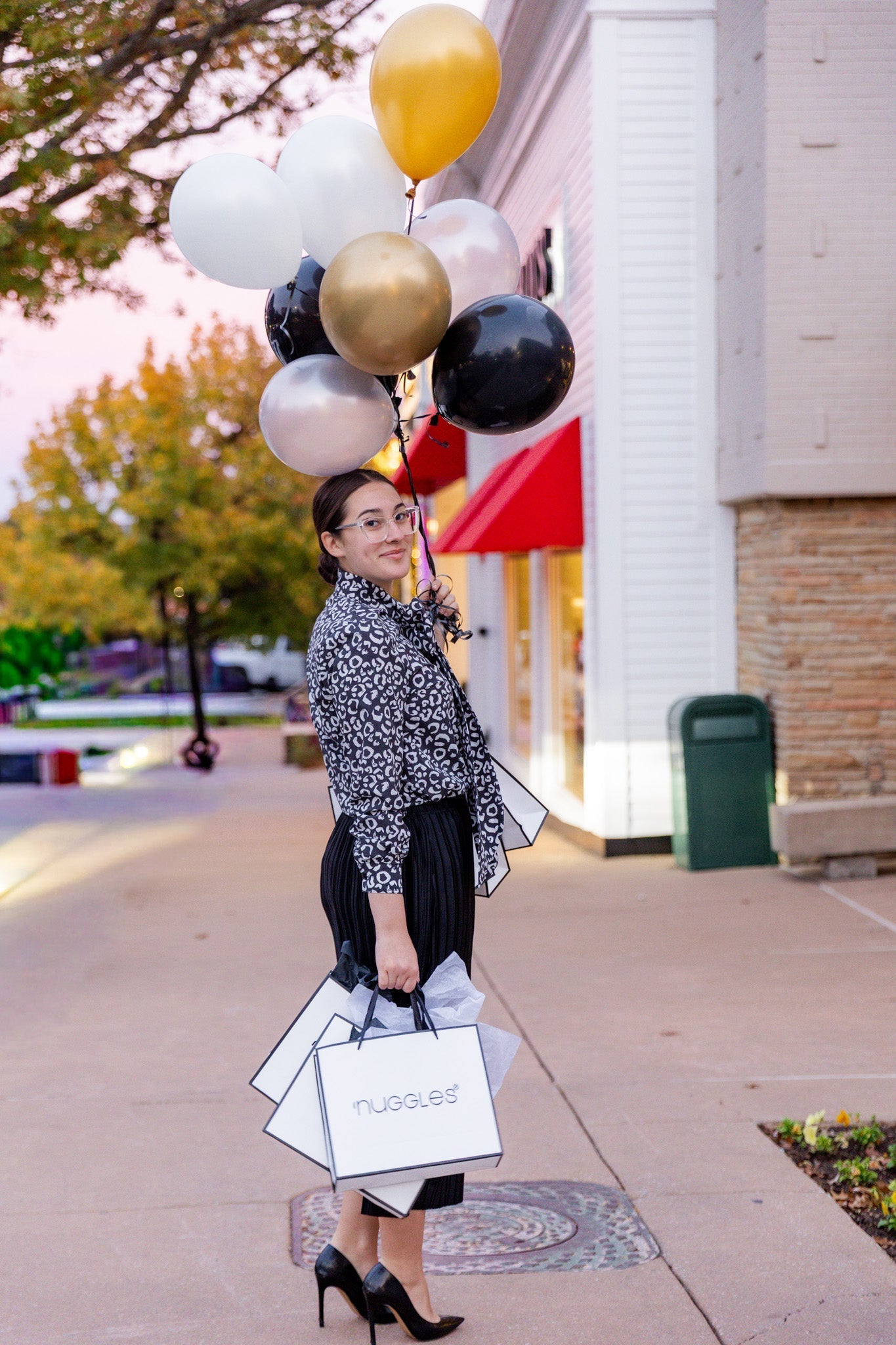 A women holding gold and black balloons celebrating Black Friday prices.