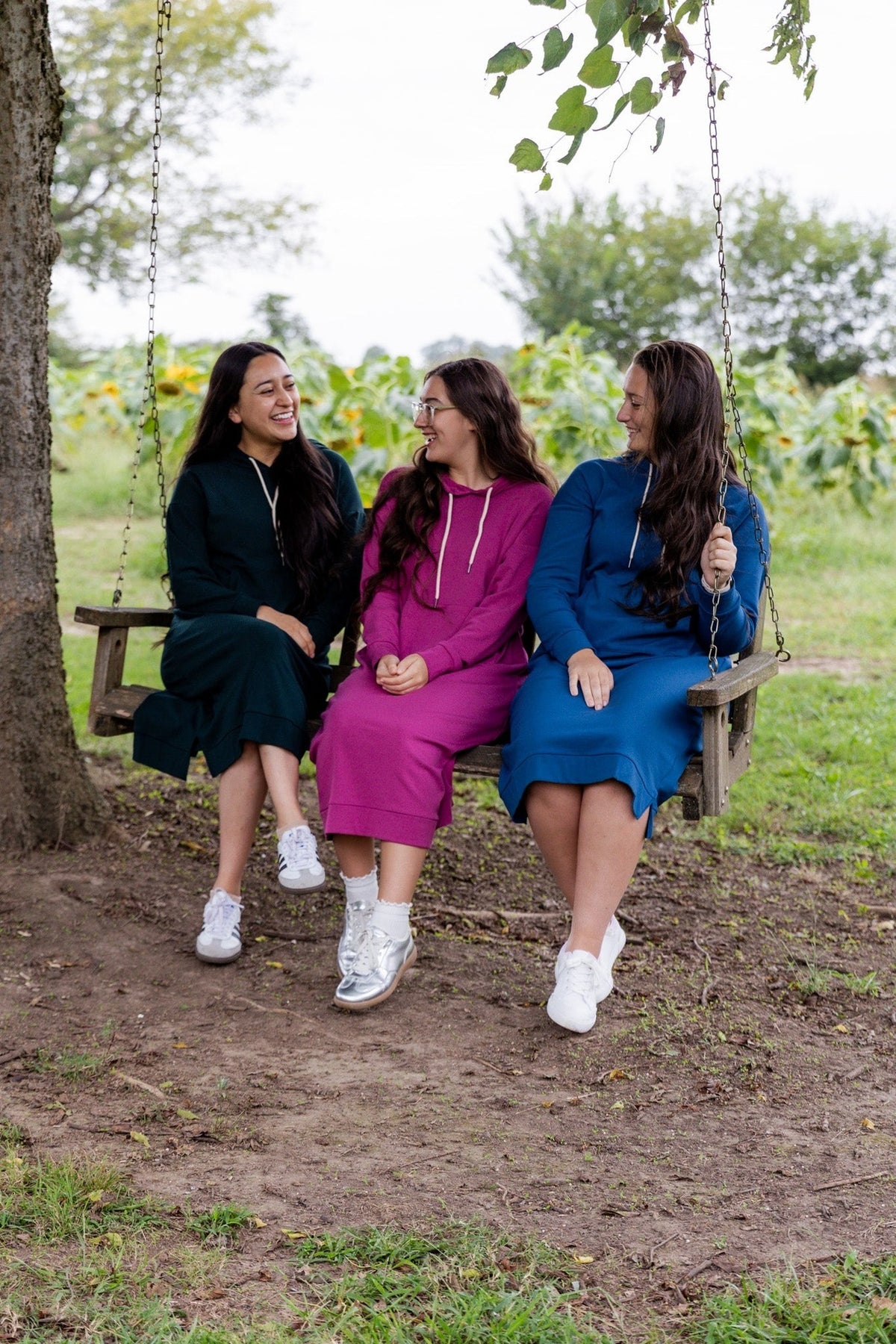 Women on a swing wearing modest hoodie fall dresses.