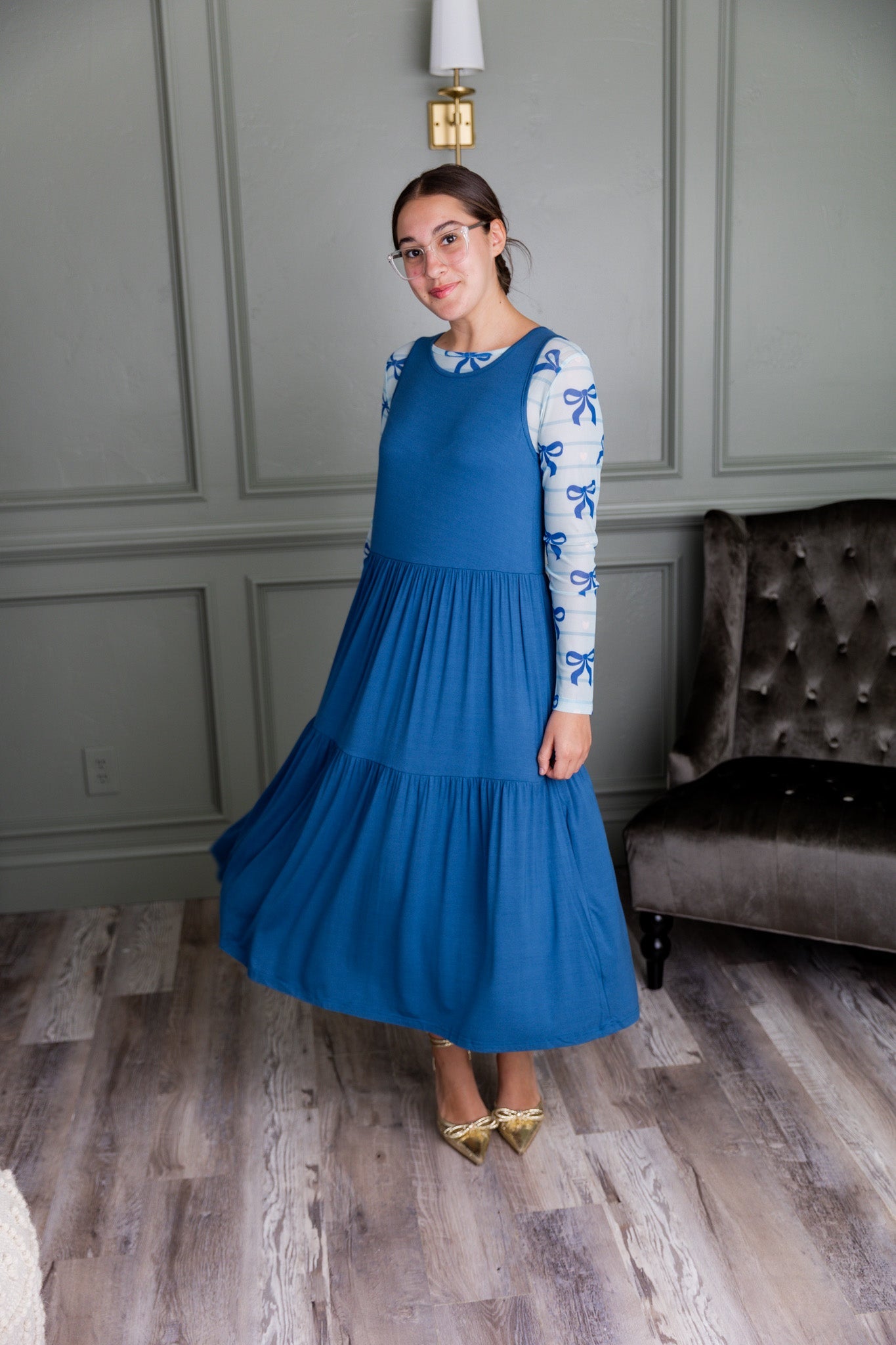 Woman wearing a modest midi length dress with a matching mesh tee. 