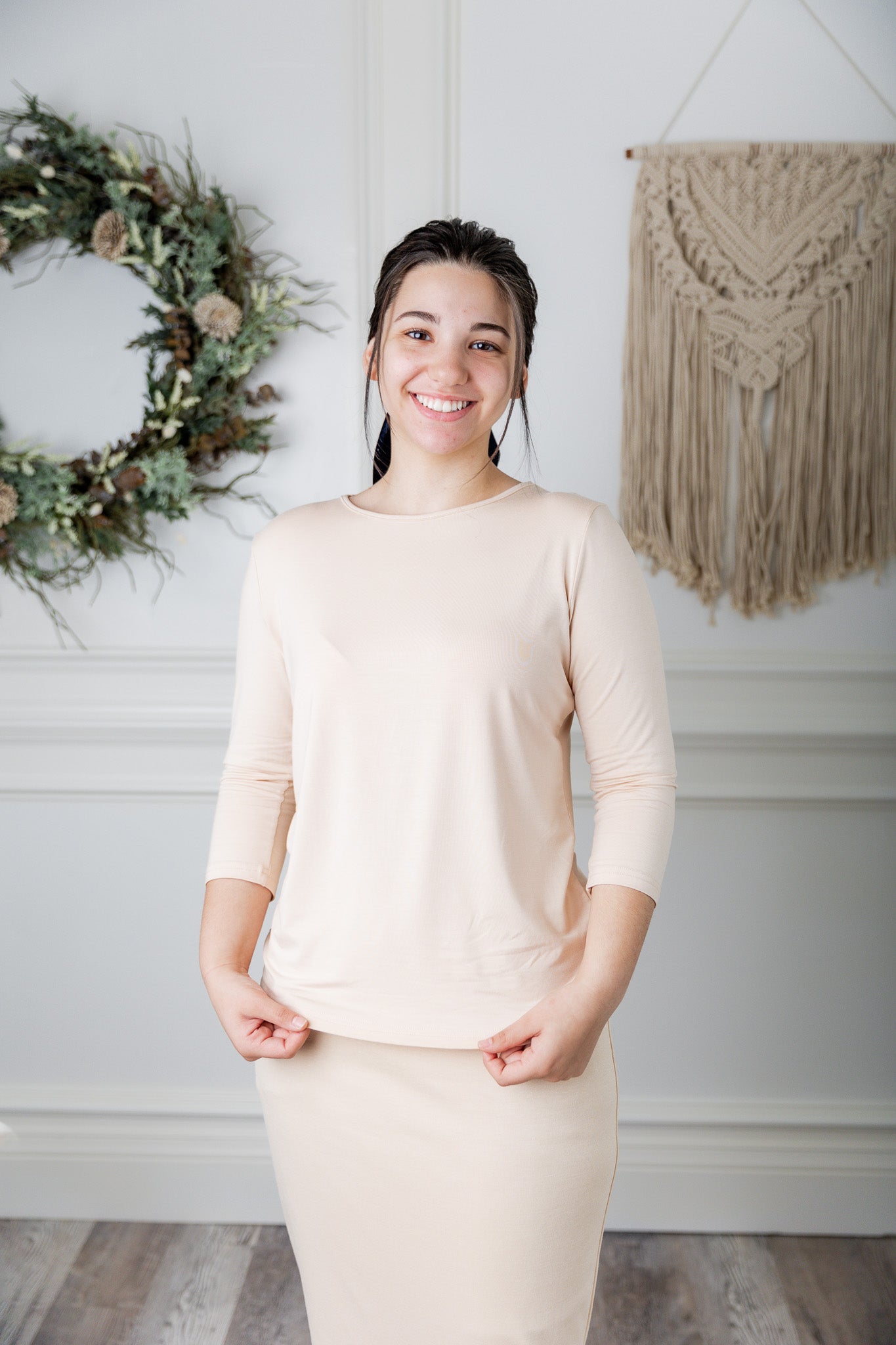 A women wearing a cream layering 3/4 sleeve t-shirt. 