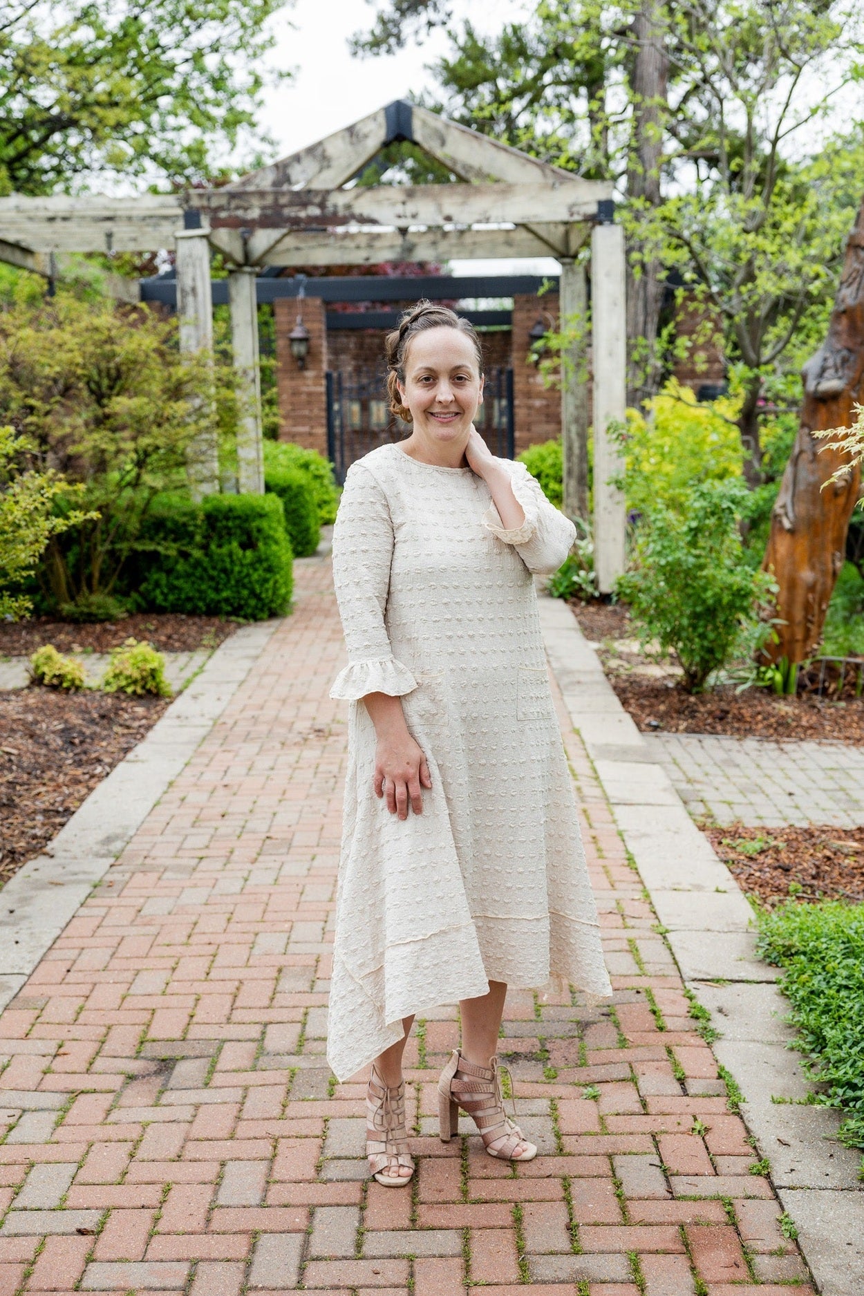 Women wearing a modest midi length dress in beige and cream. 