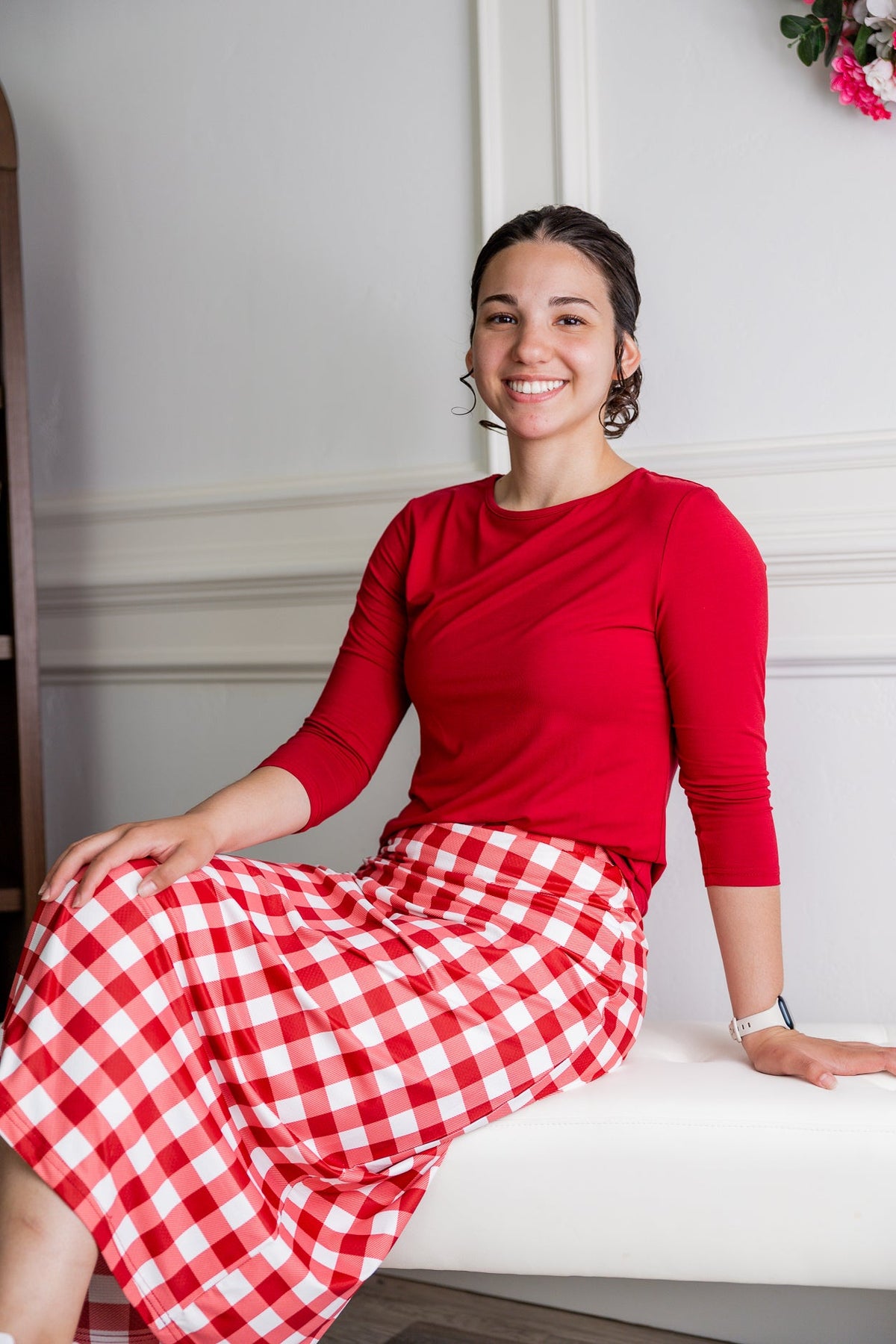 A picture of a women wearing an athletic skirt with attached leggings seated on a stool. 