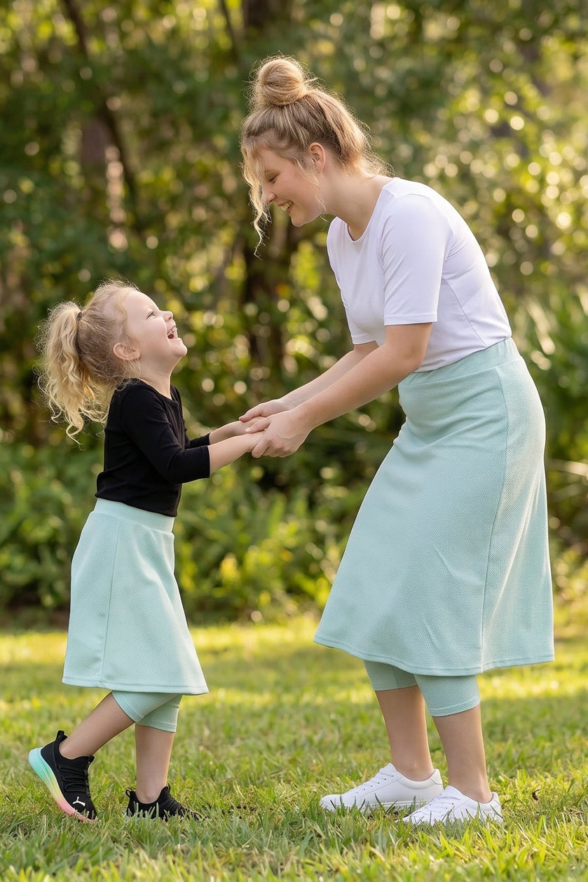 A picture of a daughter and a mom wearing modest sport skirts holding hands.