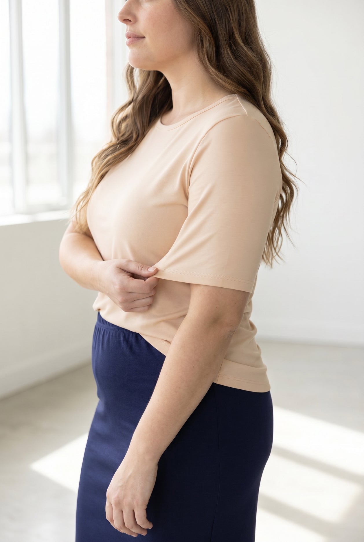 A women wearing a half sleeve tee in a neutral color. 