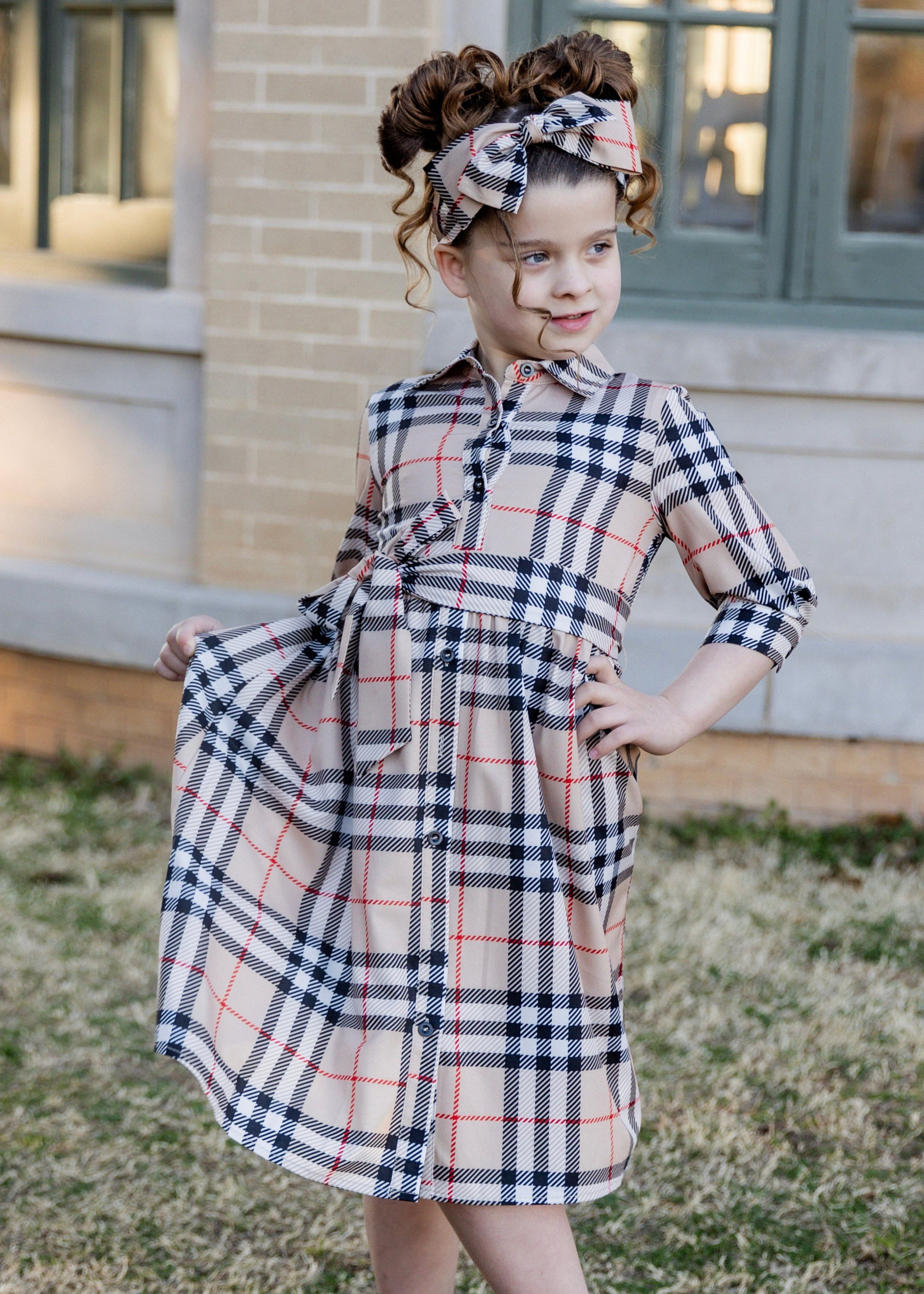 Model wearing the Nuggles® Girls' Rachel Dress and matching Headband in Sand Plaid