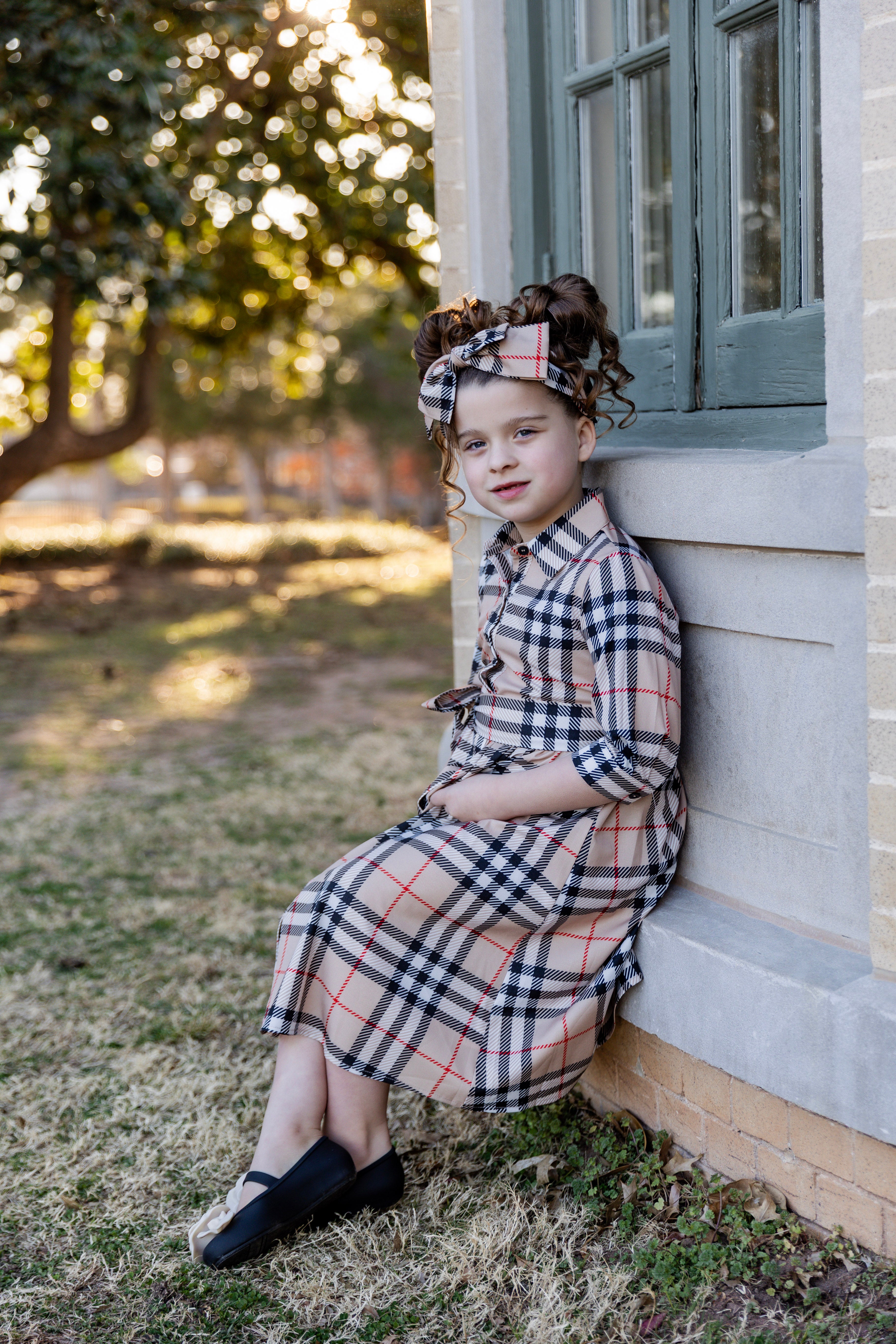 Model wearing the Nuggles® Girls' Rachel Dress in Sand Plaid