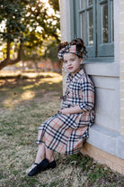 Model wearing the Nuggles® Girls' Rachel Dress in Sand Plaid