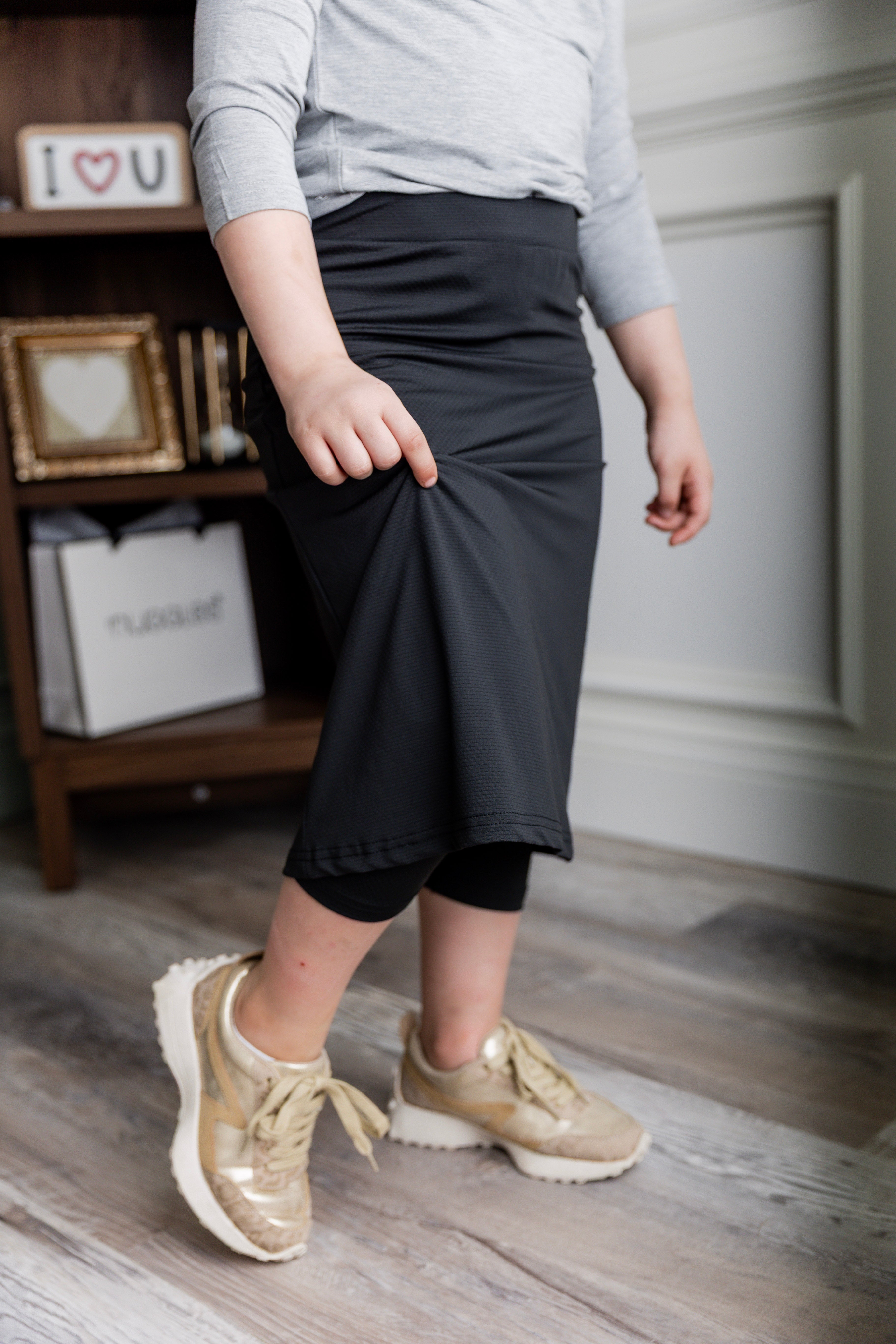 Model wearing Nuggles® Girls' All-Sport Skirt in Black