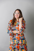 Model wearing Nuggles® Hazel Dress in Playful Patchwork print with bow-tie sleeves