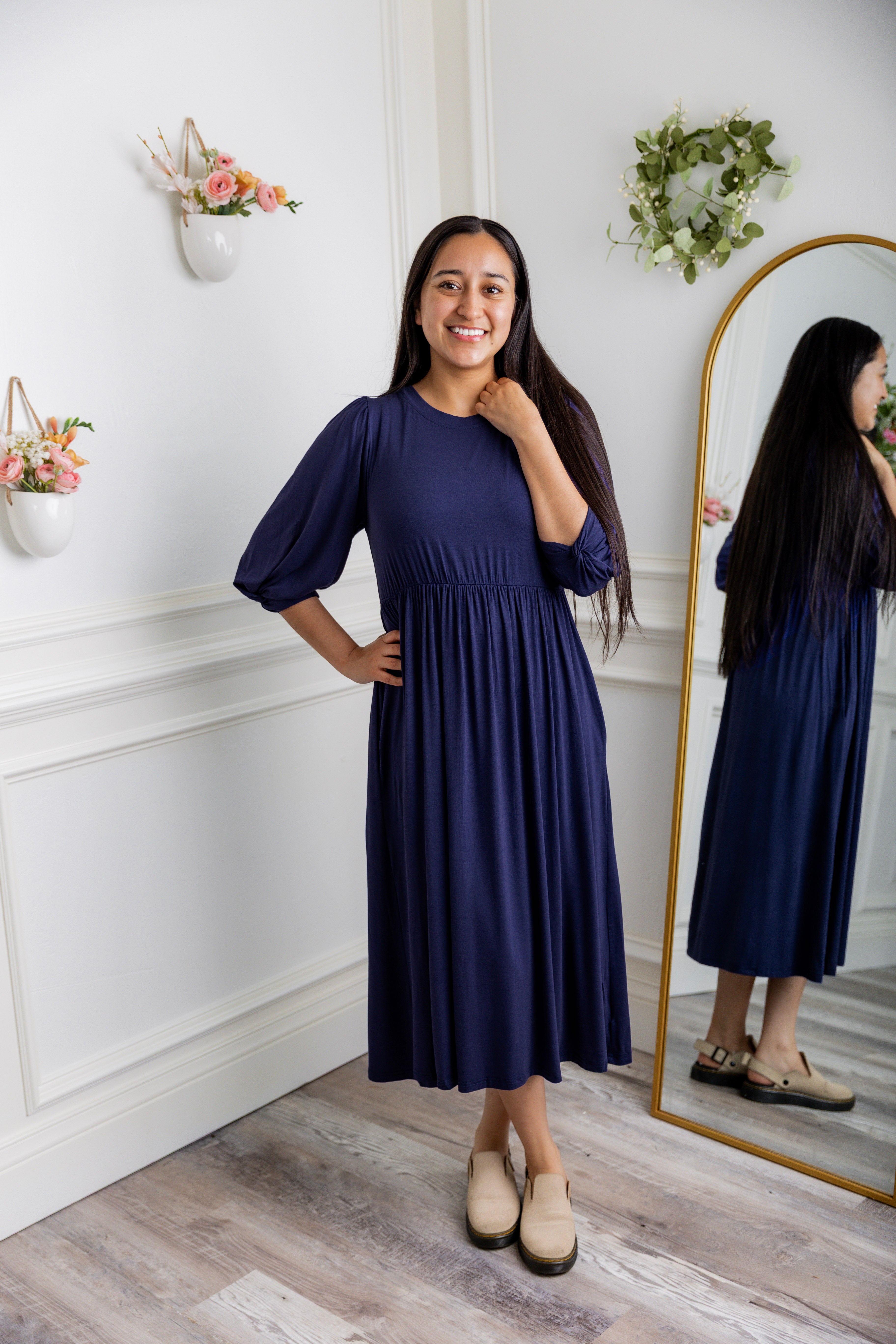 Modest Willow Solid Colors Dress by Nuggles® featuring a gathered waist, balloon sleeves, and side pockets; shown in various solid colors and angles for a stylish, comfortable everyday look.