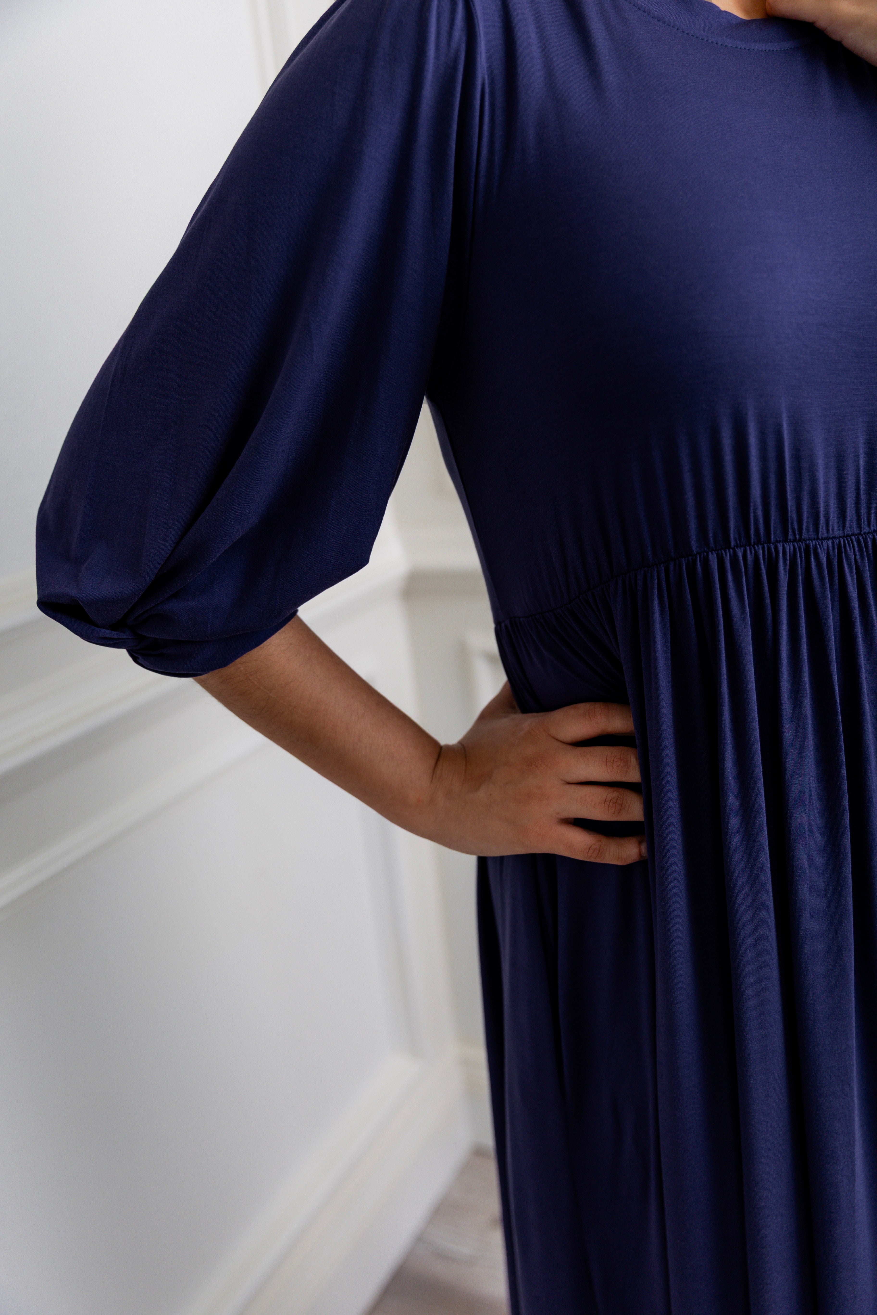 Modest Willow Solid Colors Dress by Nuggles® featuring a gathered waist, balloon sleeves, and side pockets; shown in various solid colors and angles for a stylish, comfortable everyday look.