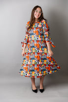 Model wearing Nuggles® Hazel Dress in Playful Patchwork print with bow-tie sleeves