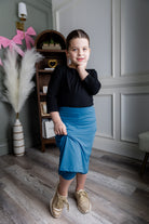 Model wearing Nuggles® Girls' All-Sport Skirt in Turquoise
