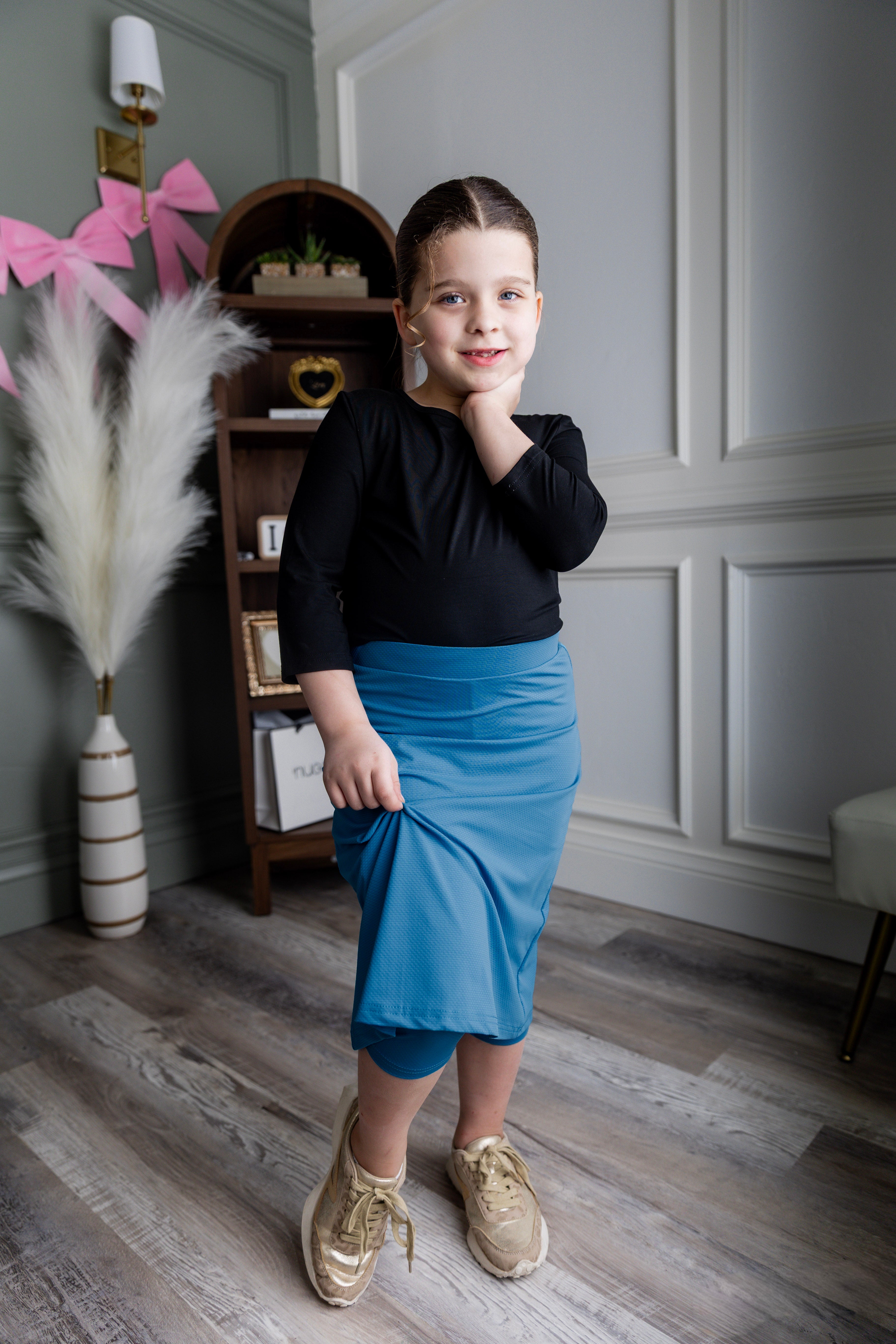 Model wearing Nuggles® Girls' All-Sport Skirt in Turquoise