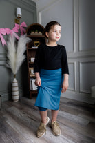 Model wearing Nuggles® Girls' All-Sport Skirt in Turquoise