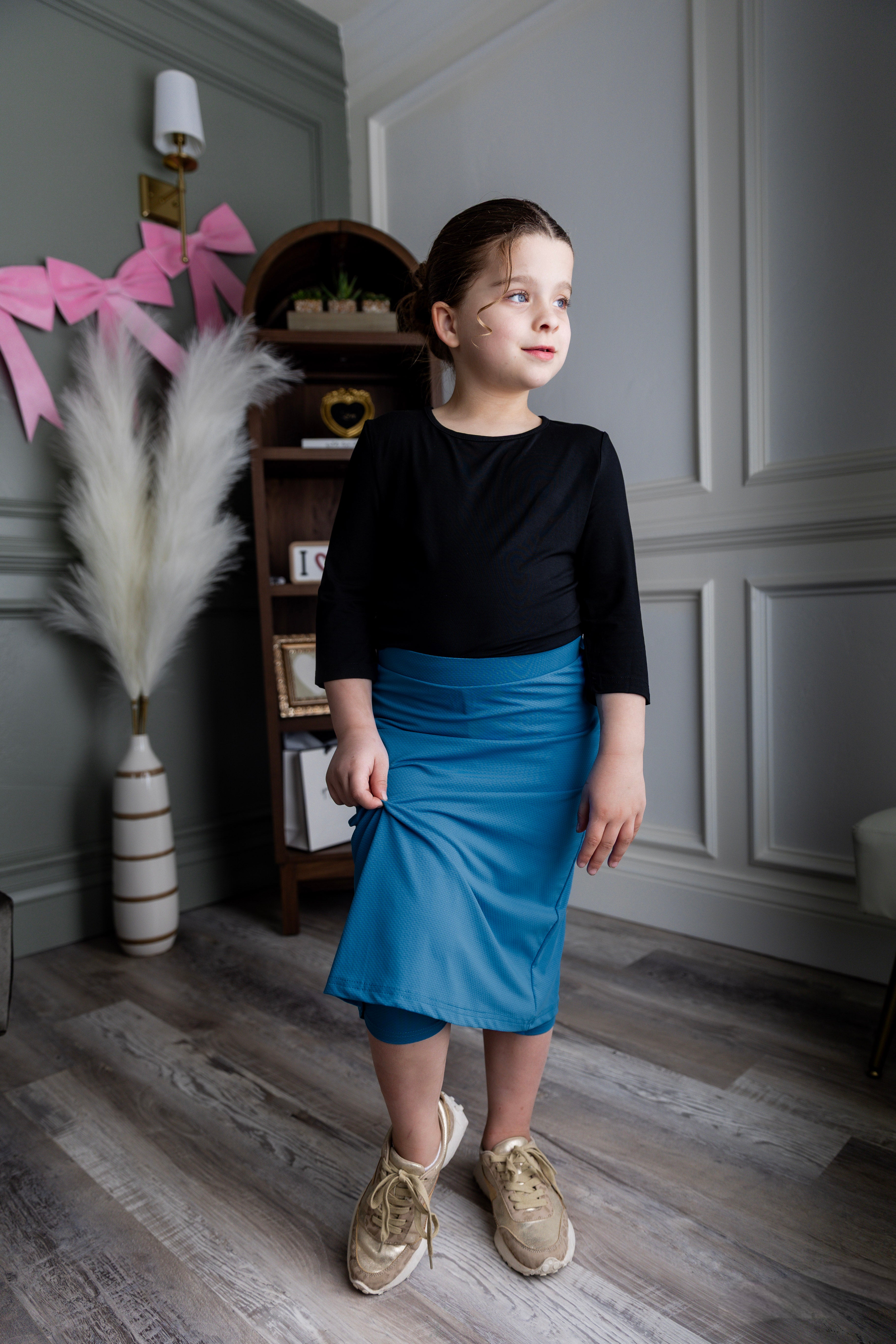 Model wearing Nuggles® Girls' All-Sport Skirt in Turquoise