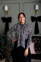 Model wearing Nuggles® Felicity top with large bow tie neckline, modest women's blouse.