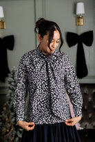 Model wearing Nuggles® Felicity top with large bow tie neckline, modest women's blouse.