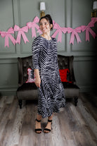 Model wearing Nuggles® Hazel Dress in Zebra Swirl black and white print with bow sleeves.