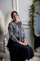 Model wearing Nuggles® Felicity top with large bow tie neckline, modest women's blouse.