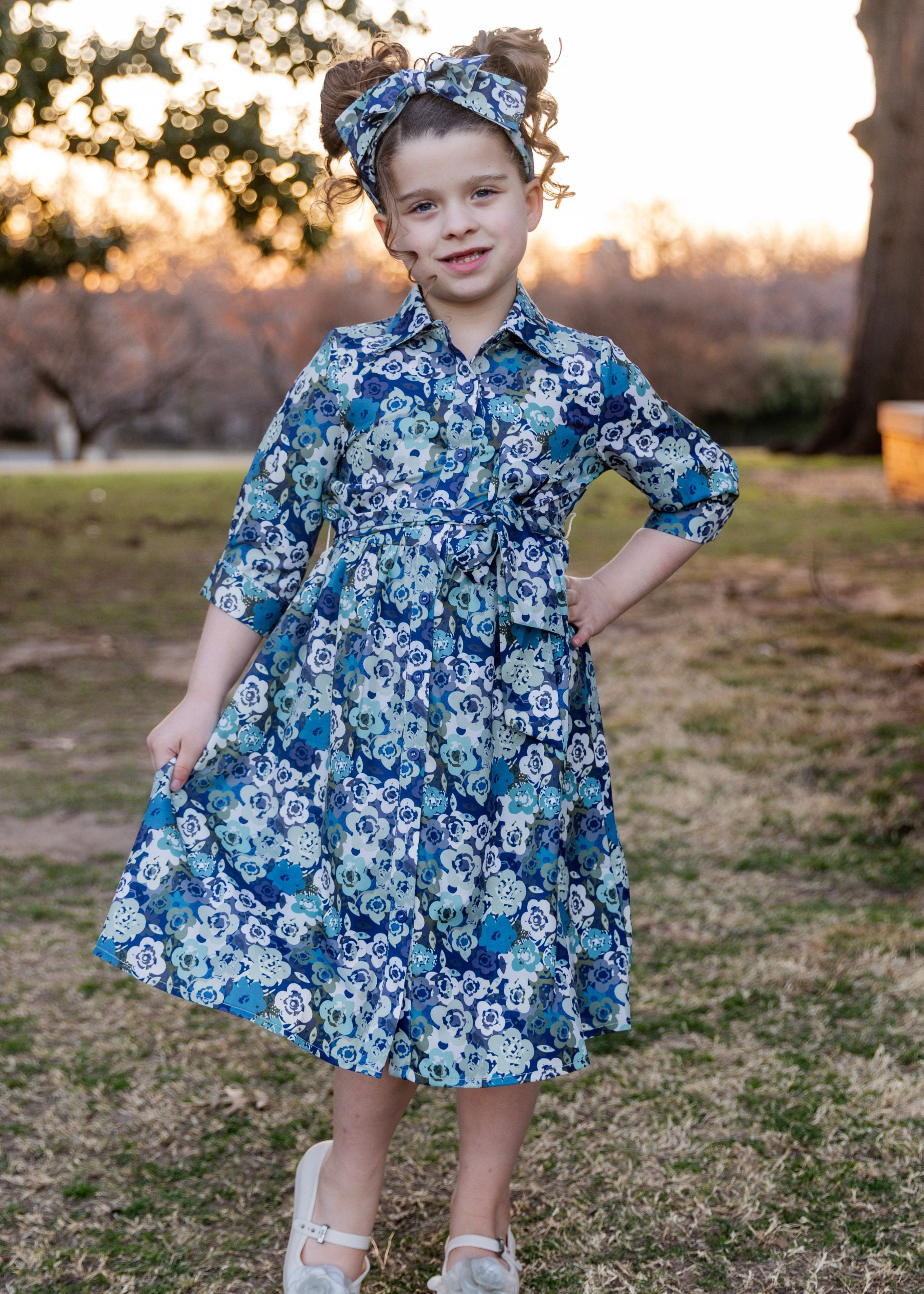 Model wearing the Nuggles® Girls' Rachel Dress and matching Headband in Storm Brush