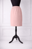 rose skirt on a mannequin against a white paneled wall.