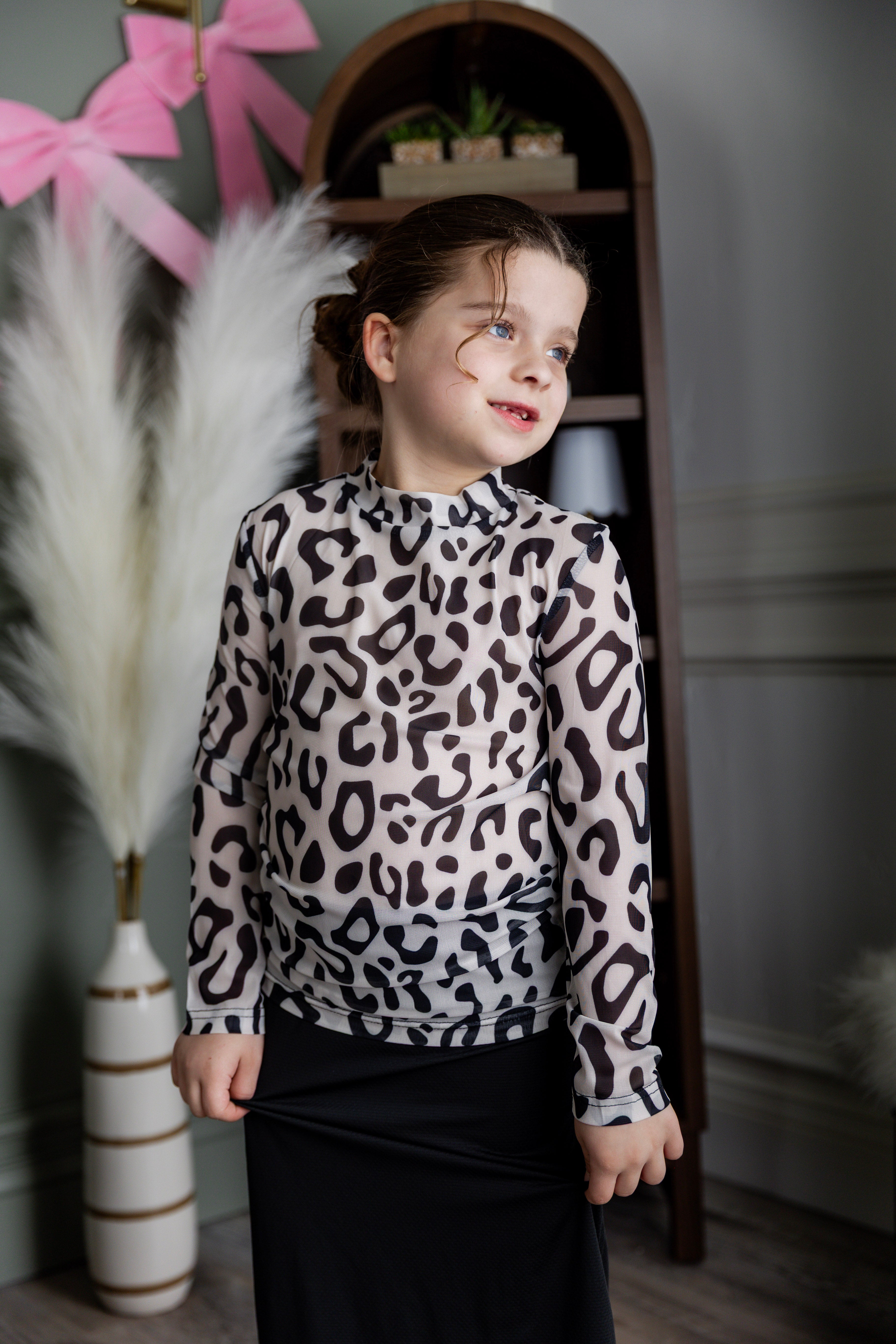 Model wearing Nuggles® Girls' Mesh Tee in Snow Leopard
