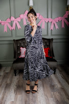 Model wearing Nuggles® Hazel Dress in Zebra Swirl black and white print with bow sleeves.