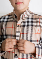 Model wearing Nuggles® Boys' Button Down Shirt Sand Plaid