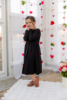 Model wearing the Nuggles® Girls' Farah Dress in Black