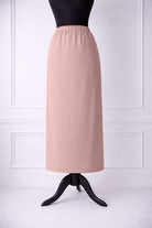 rose skirt on a mannequin against a white paneled wall.