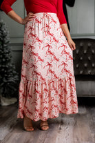 Model wearing the Nuggles® Sage Skirt in pink with red bow print, showcasing a tiered ruffle hem and soft, stretchy waistband.