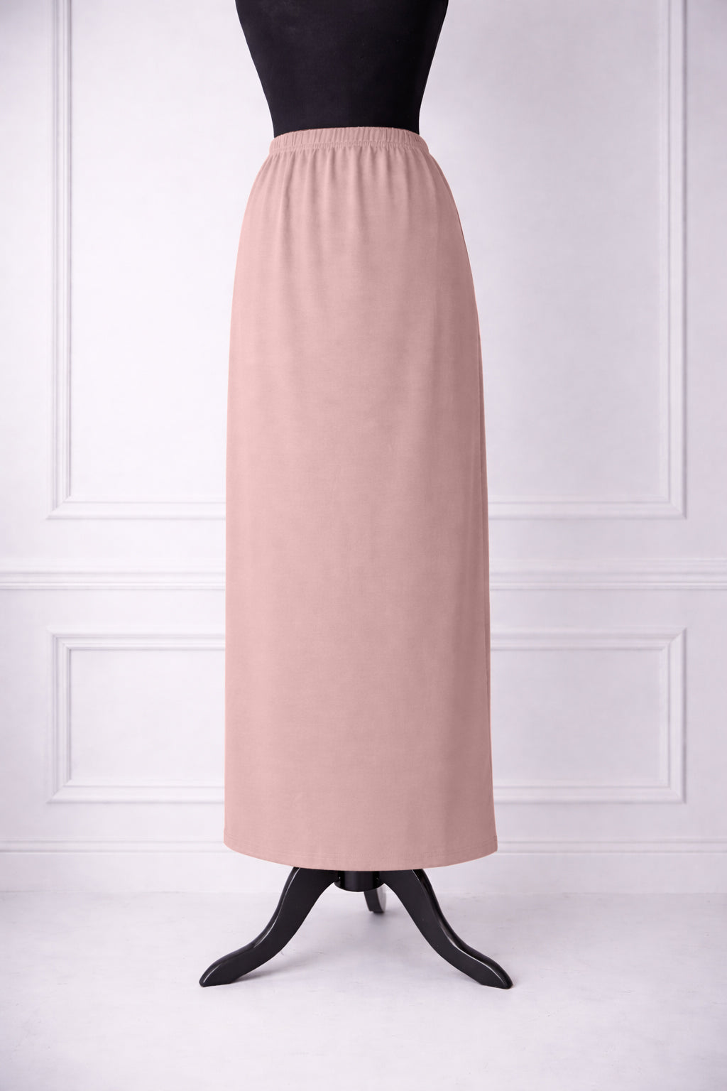 rose skirt on a mannequin against a white paneled wall.