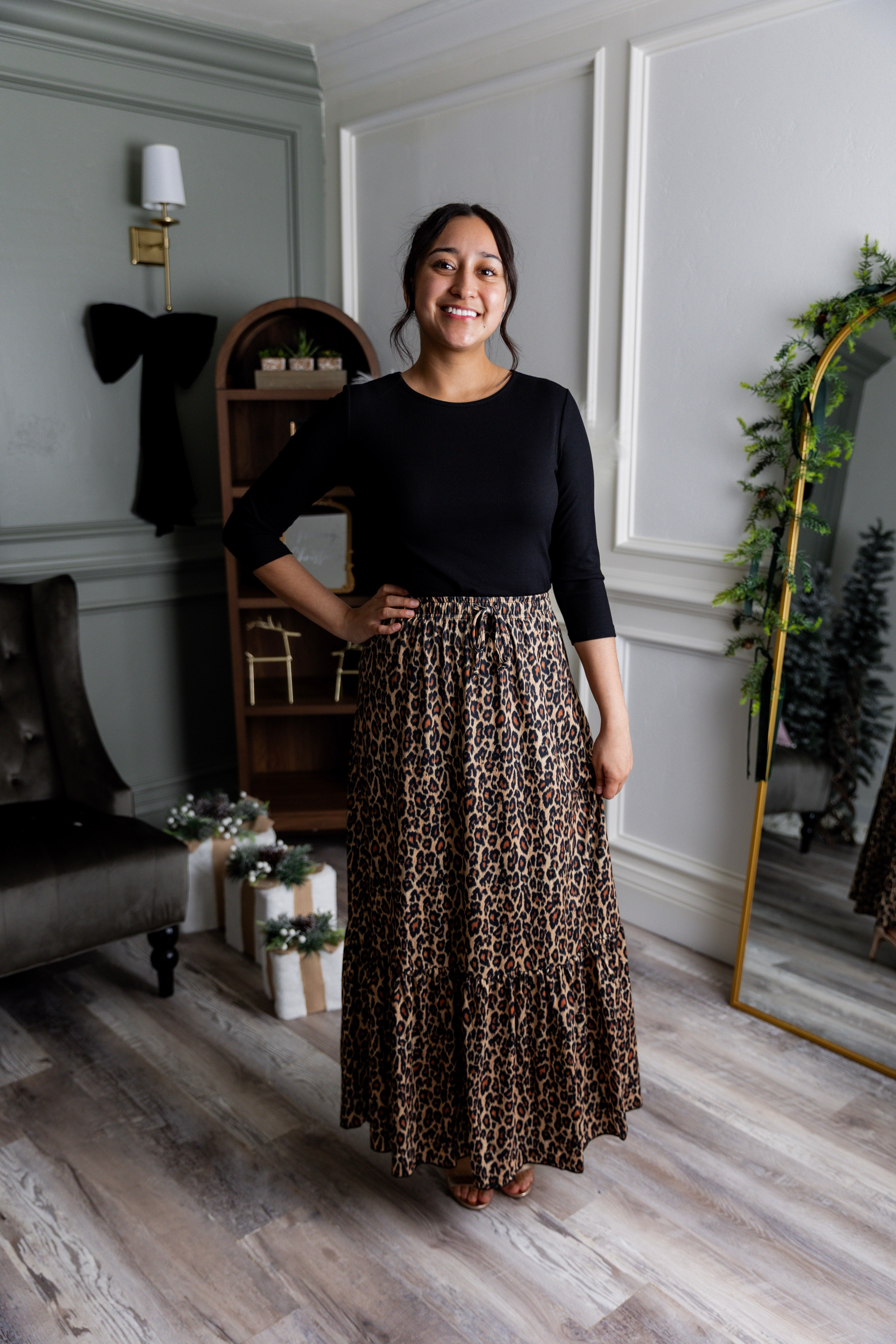 Model wearing the Nuggles® Sage Skirt in leopard print, designed with a flowy tiered hem and comfortable elastic waistband.