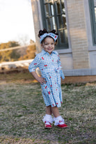 Model wearing the Nuggles® Girls' Rachel Dress and headband in Sweet Cherry Check