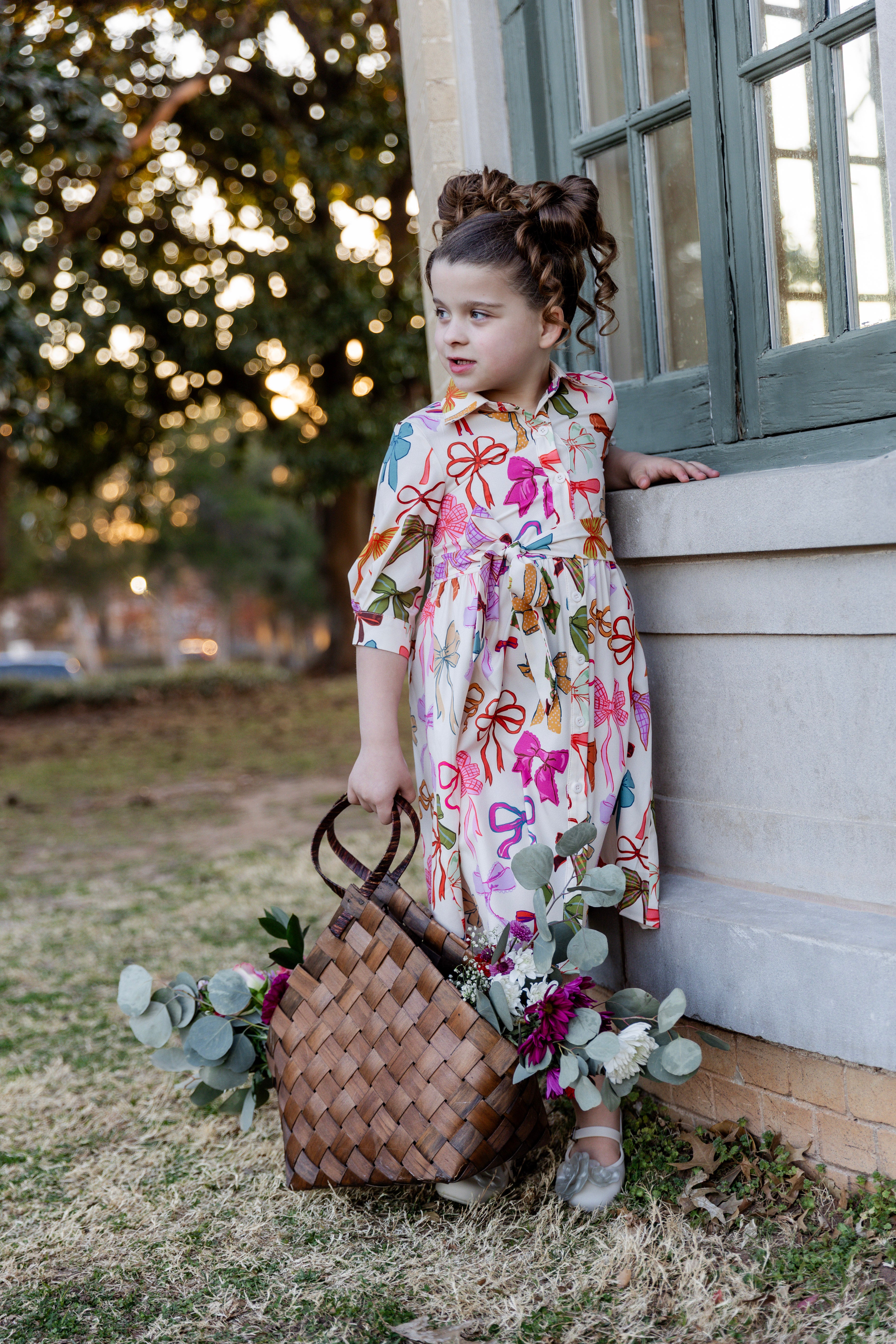 Model wearing the Nuggles® Girls' Rachel Dress in Bow Garden