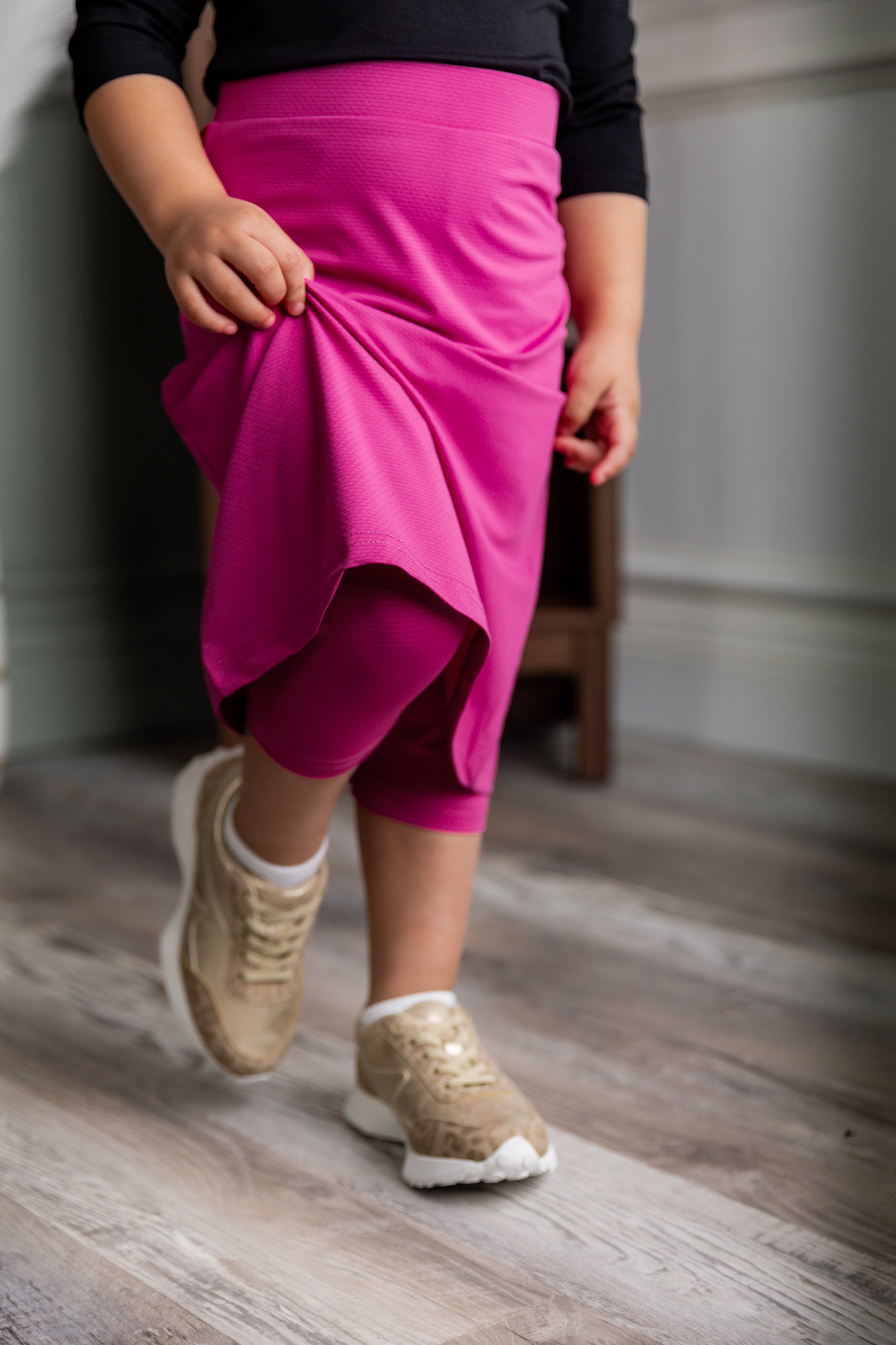 Model wearing Nuggles® Girls' All-Sport Skirt in Hot Pink