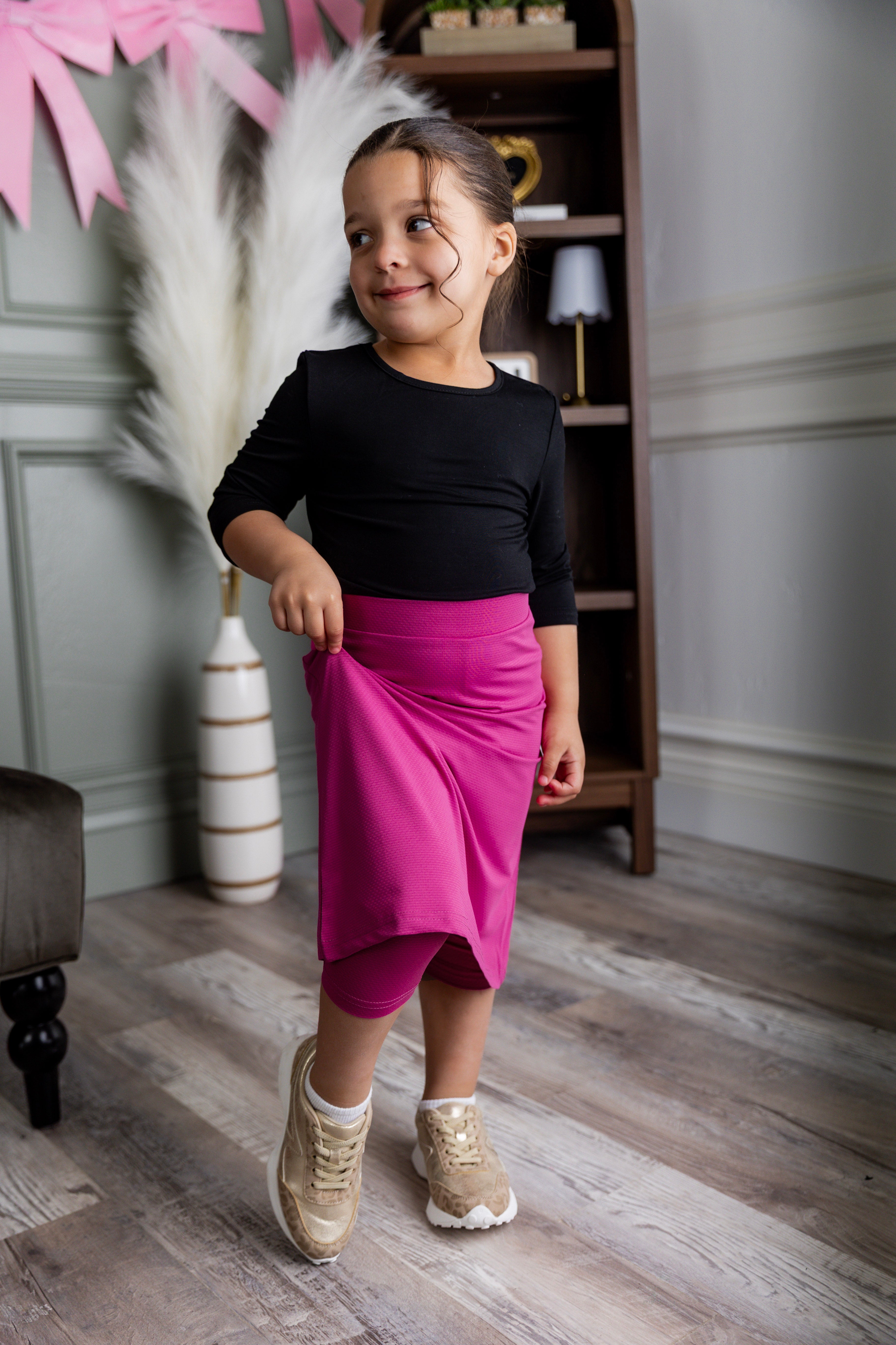 Model wearing Nuggles® Girls' All-Sport Skirt in Hot Pink