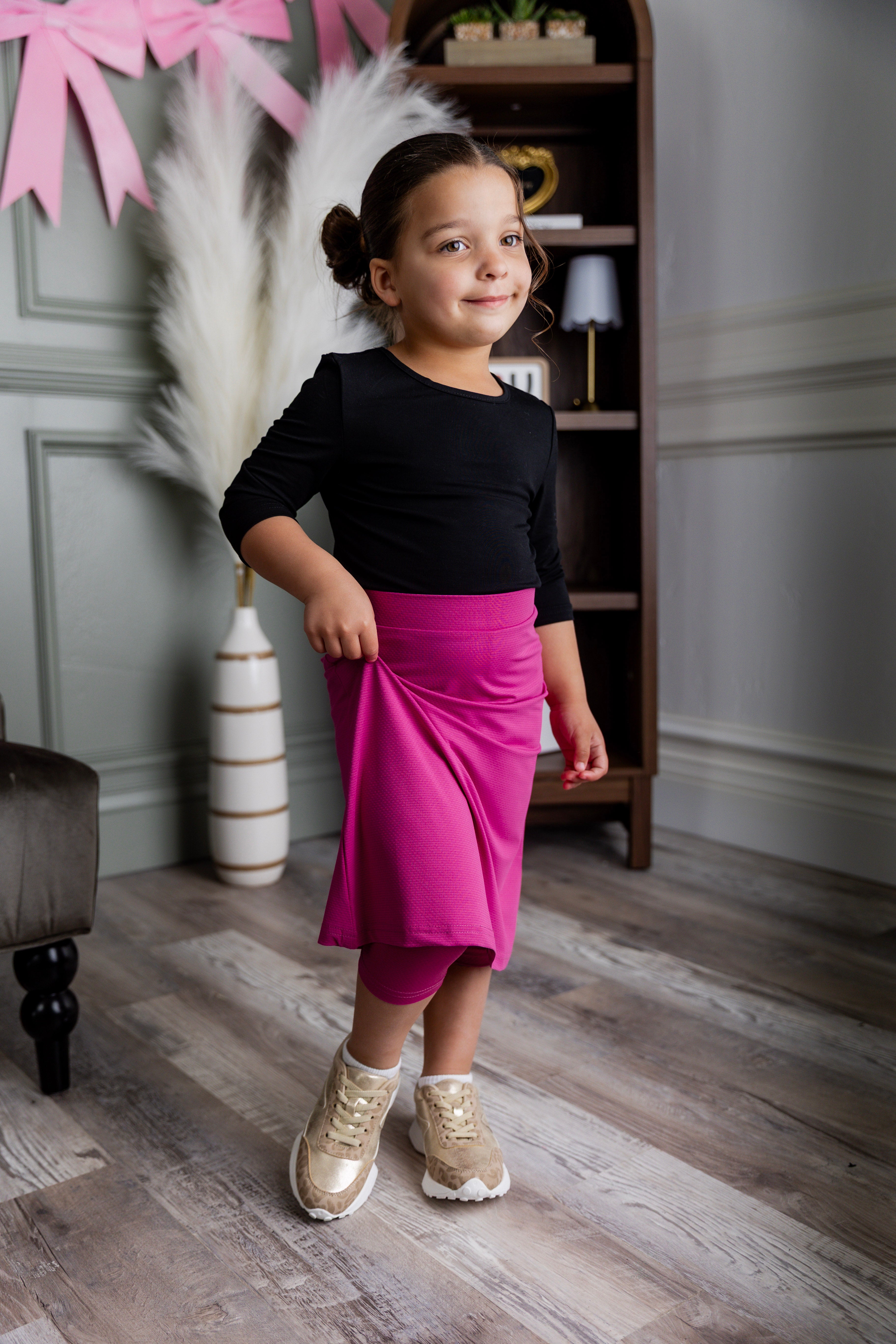 Model wearing Nuggles® Girls' All-Sport Skirt in Hot Pink