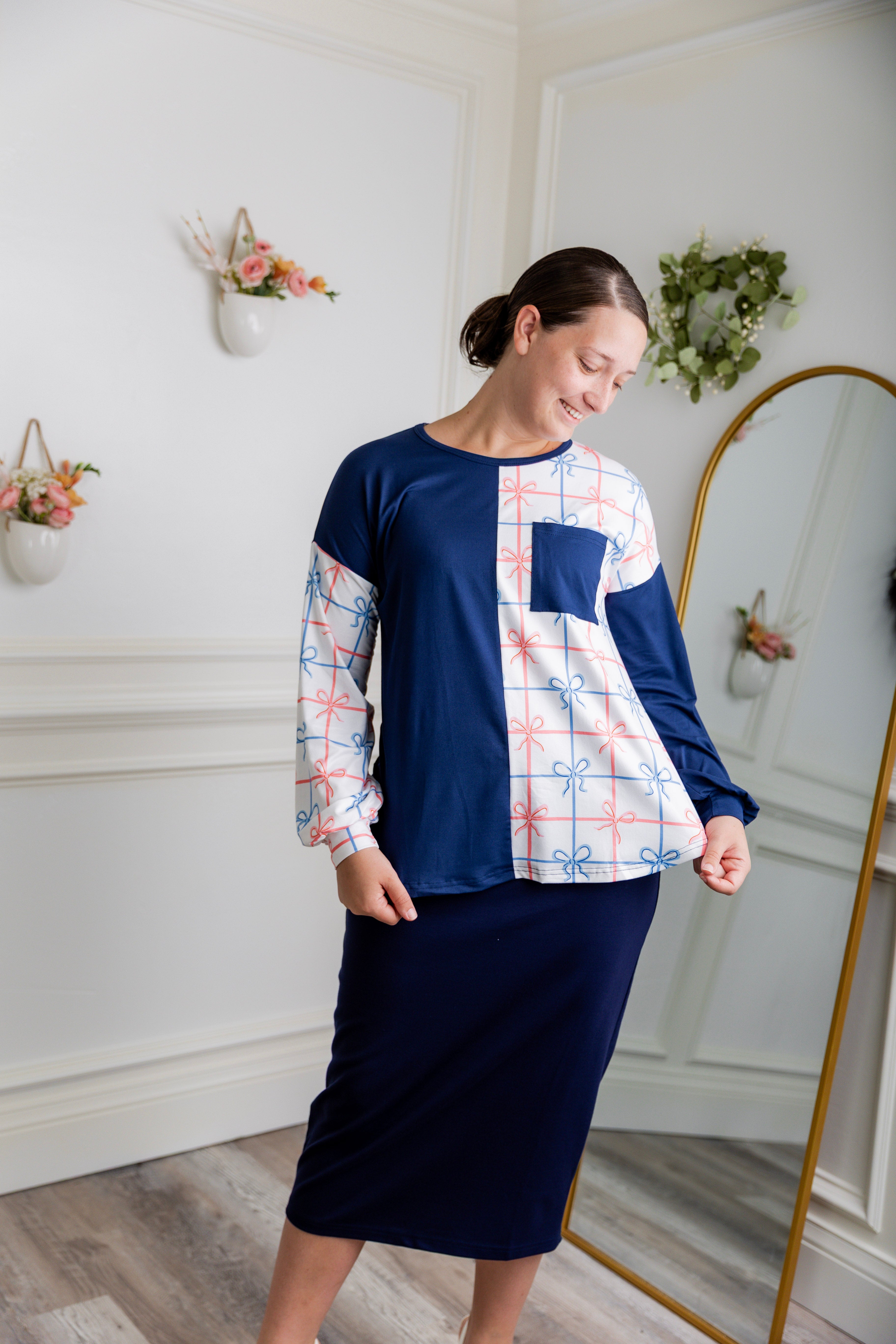 Model wearing the Nuggles® Harlow Top with red and navy color block design.