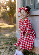 Model wearing the Nuggles® Girls' Rachel Dress and matching Headband in Cherry Jam