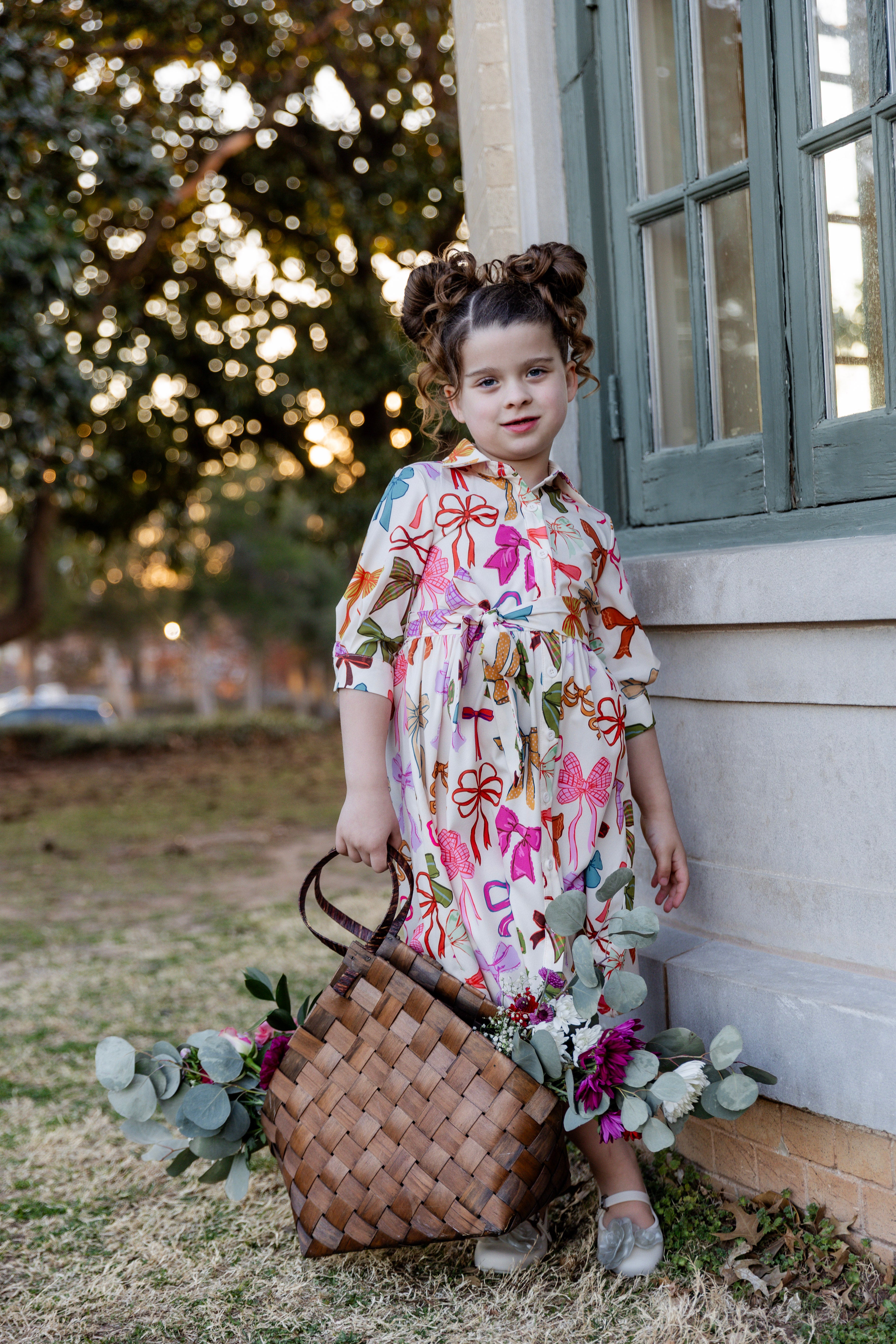 Model wearing the Nuggles® Girls' Rachel Dress in Bow Garden