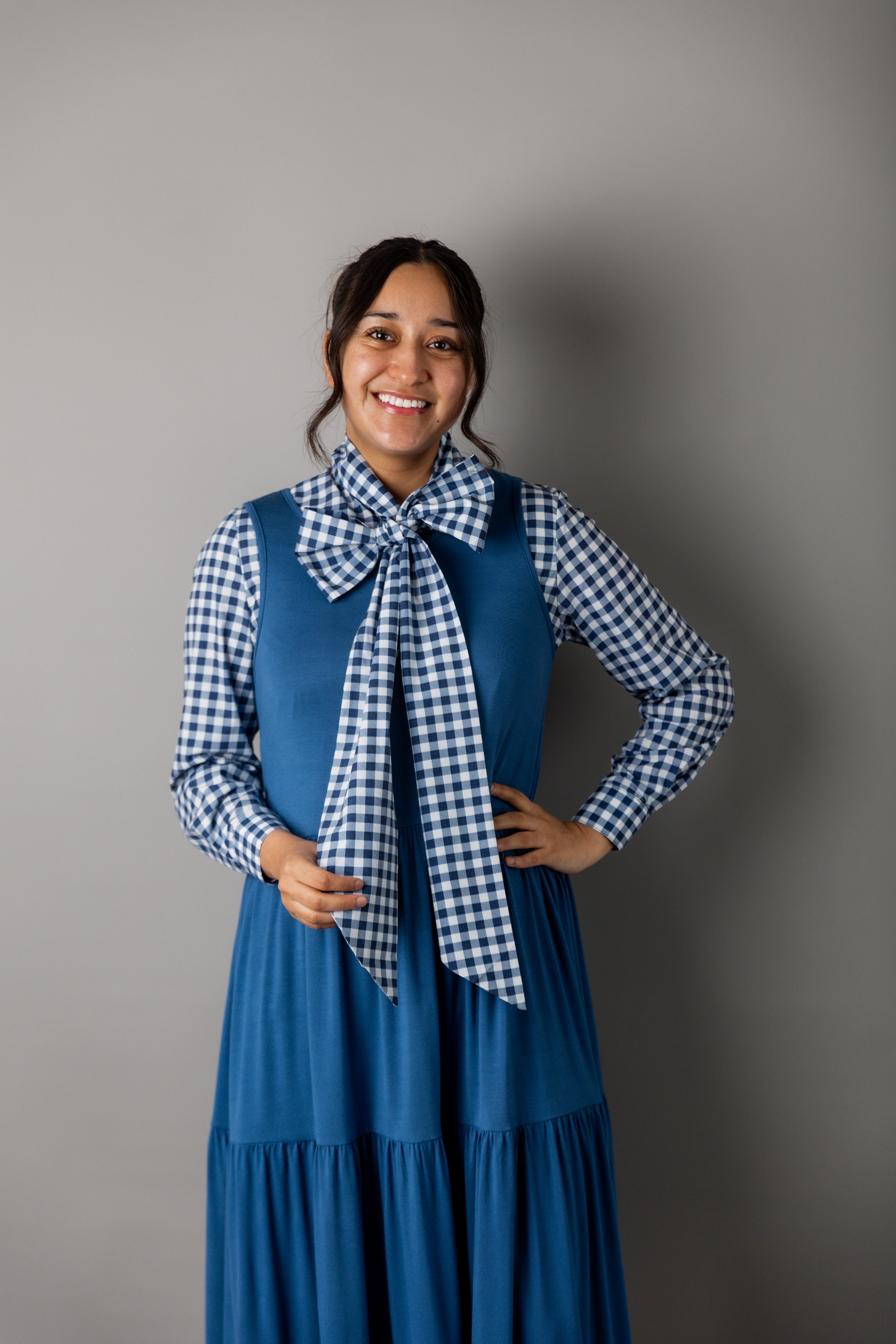 Model wearing Nuggles® Felicity top with large bow tie neckline, modest women's blouse.