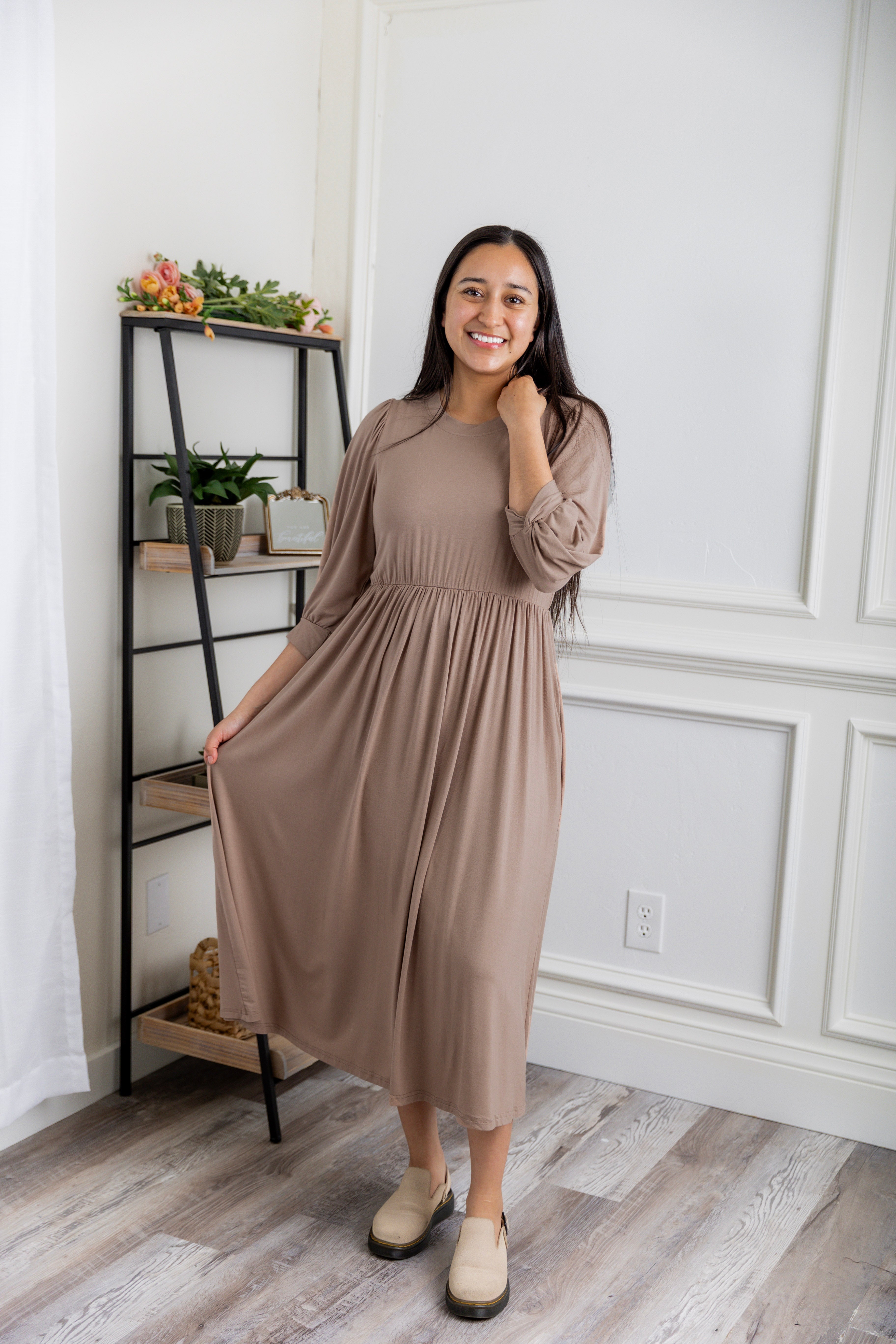 Modest Willow Solid Colors Dress by Nuggles® featuring a gathered waist, balloon sleeves, and side pockets; shown in various solid colors and angles for a stylish, comfortable everyday look.