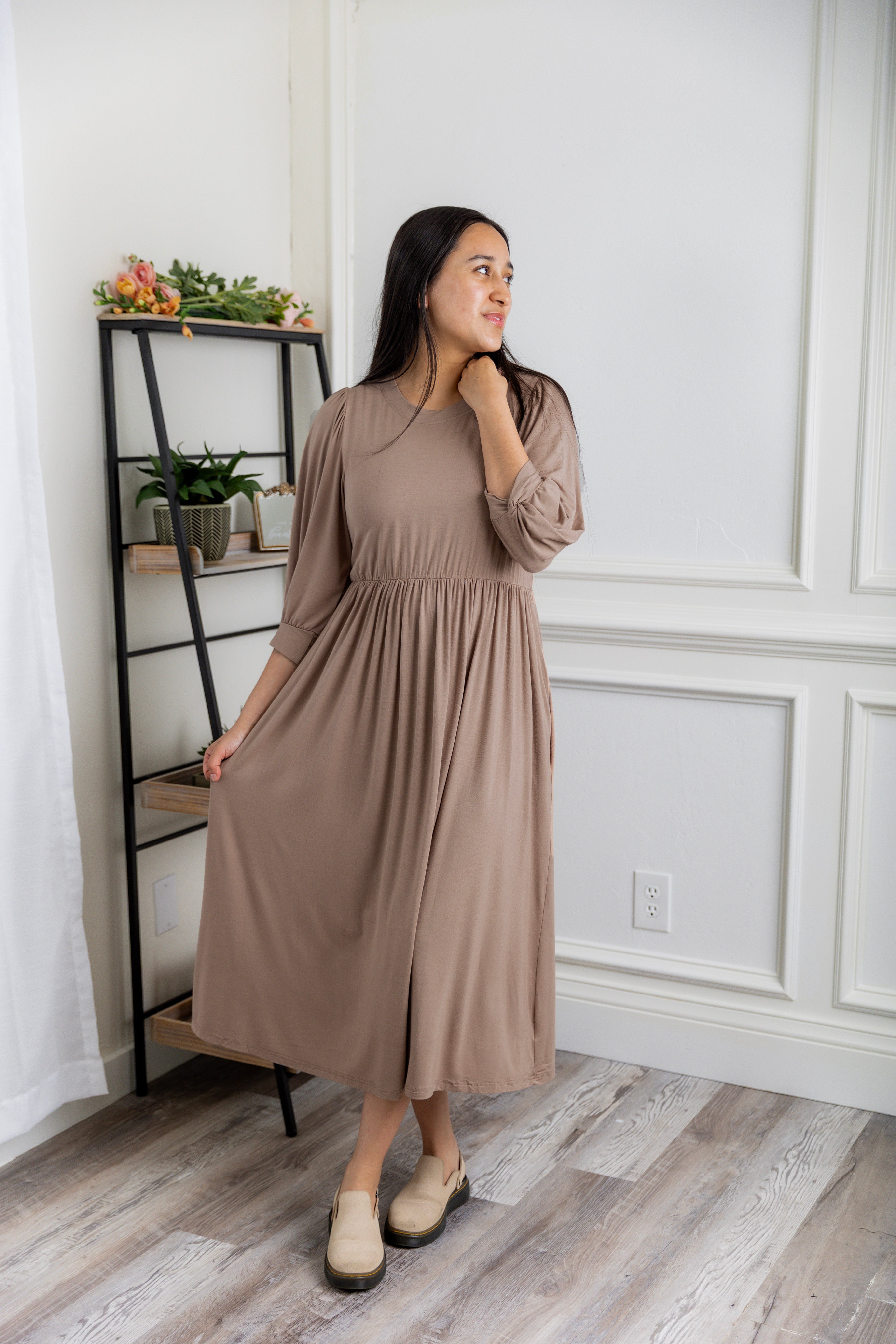 Modest Willow Solid Colors Dress by Nuggles® featuring a gathered waist, balloon sleeves, and side pockets; shown in various solid colors and angles for a stylish, comfortable everyday look.