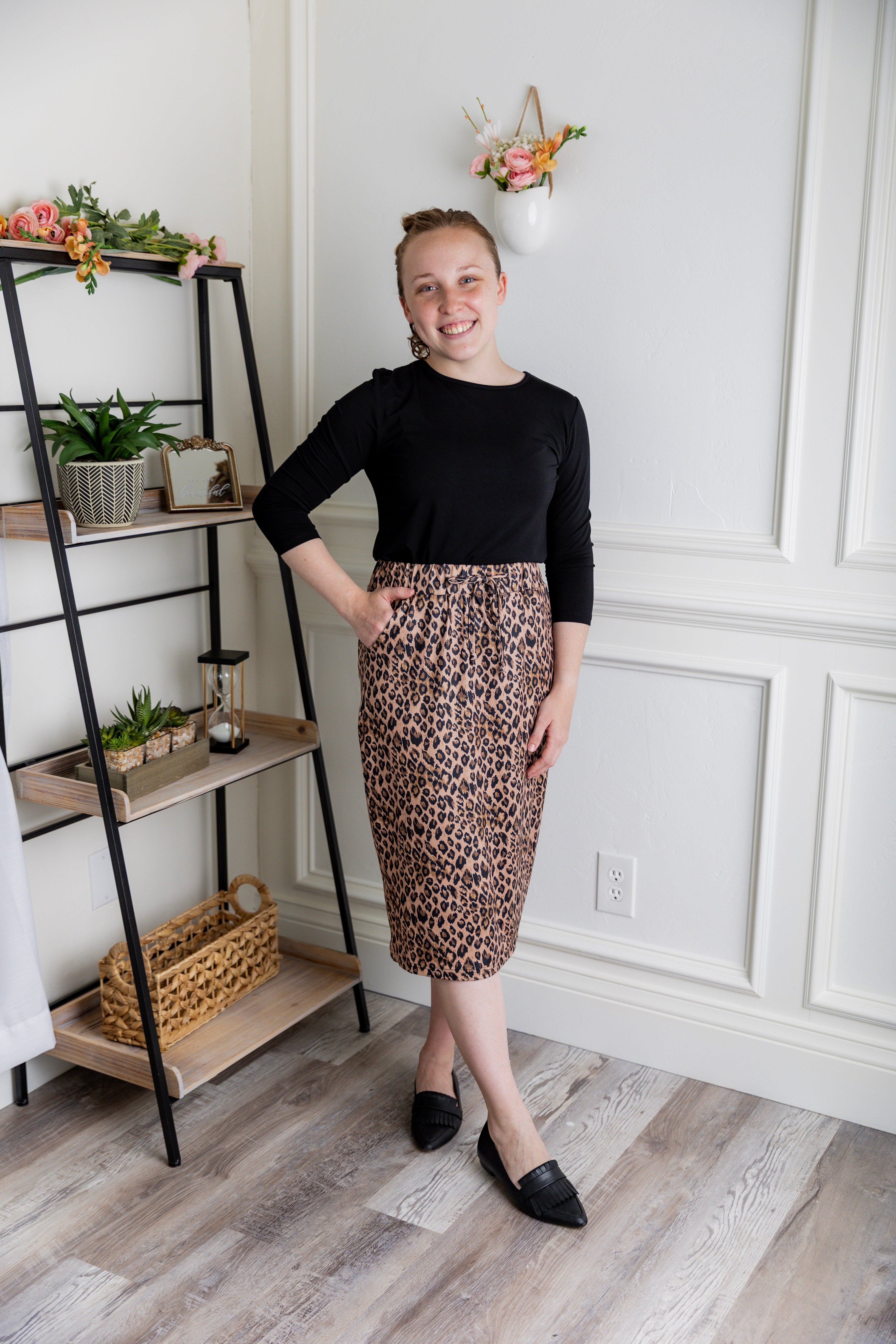 Woman wearing a modest 27-inch leopard print knit skirt with drawstring waist and side pockets.