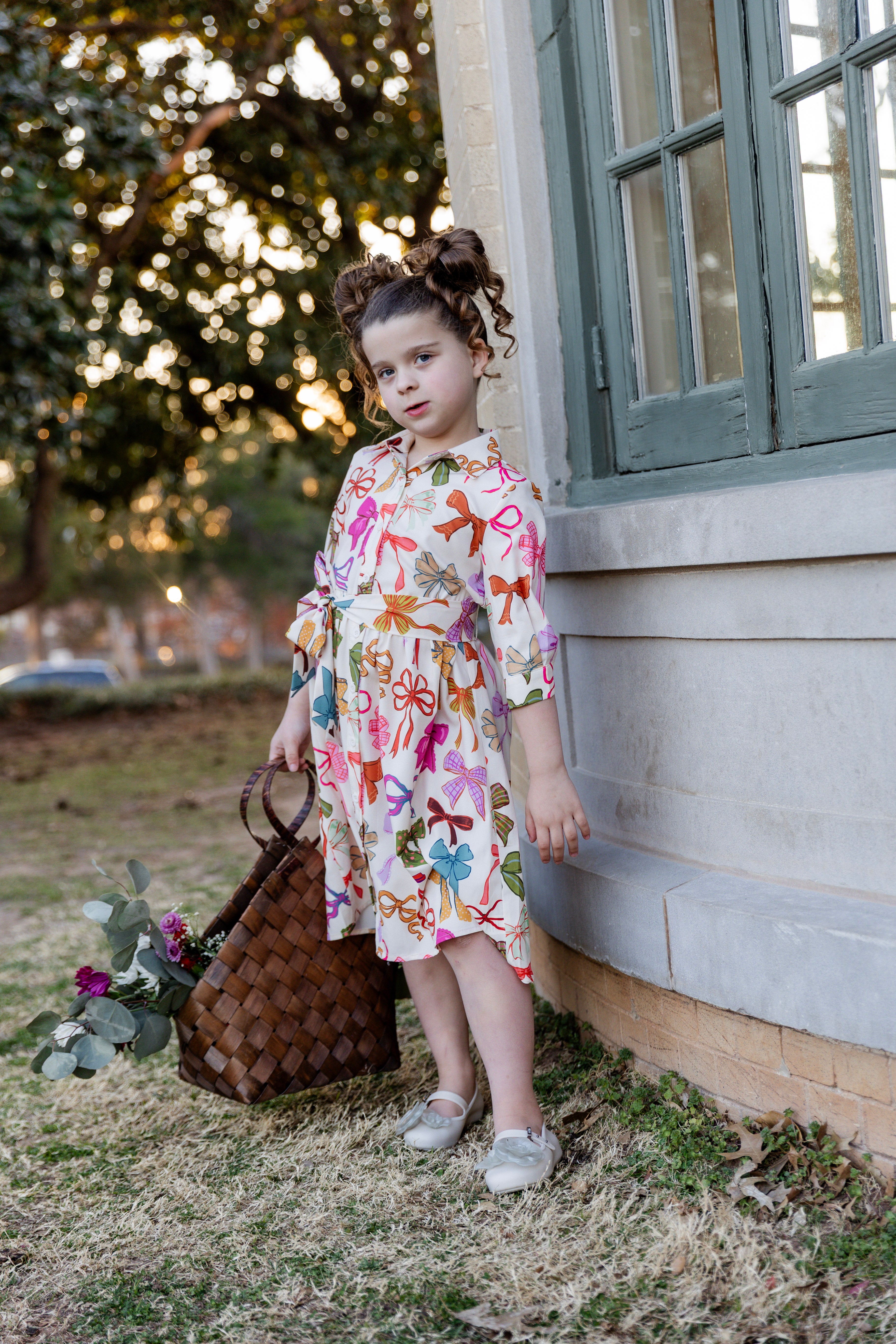 Model wearing the Nuggles® Girls' Rachel Dress in Bow Garden