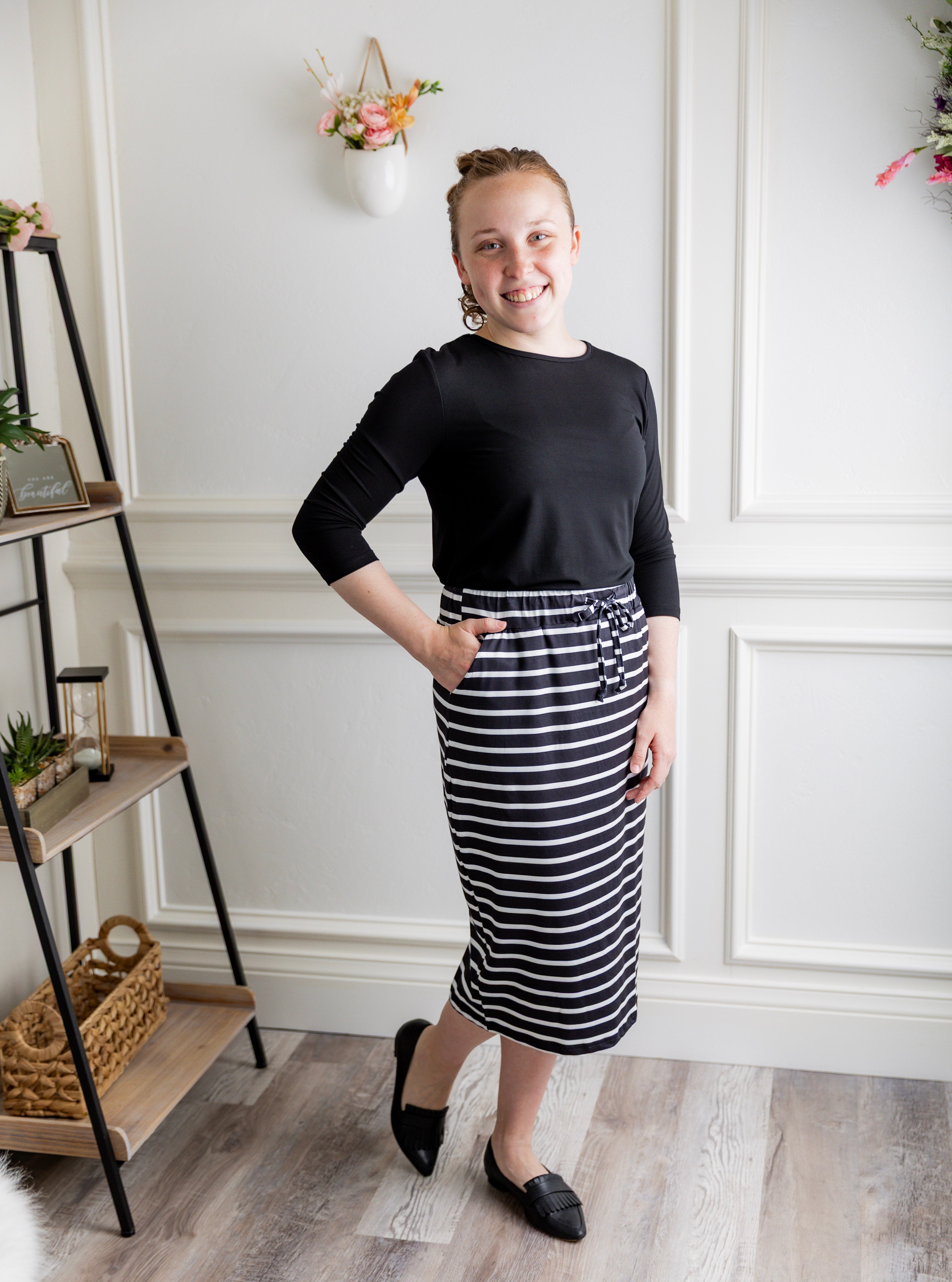 Woman wearing a modest 27-inch striped knit skirt in black and white with adjustable drawstring waistband.